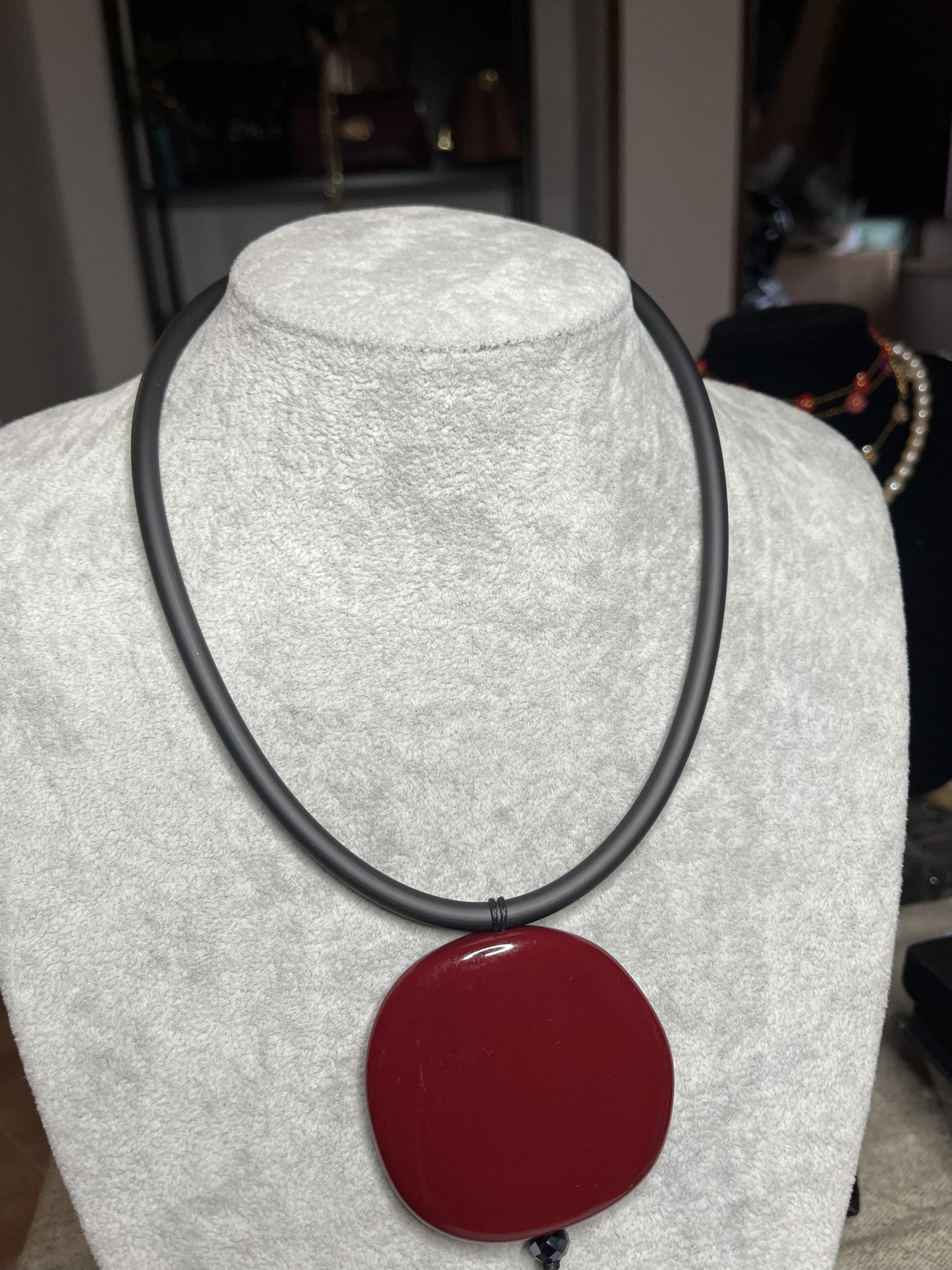 Collana con ciondolo rotondo bordeaux in resina su cordino nero in caucciù