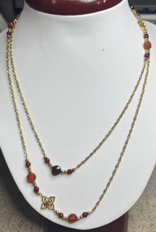 Collana doppio giro in acciaio inossidabile con pietre di agata rosse o verdi/azzurre ciondolo decorativo, esposta su busto bianco