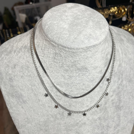 Collana Double Star in acciaio placcato argento con doppia catena layered, una snake liscia e una con stelle decorative, esposta su busto grigio