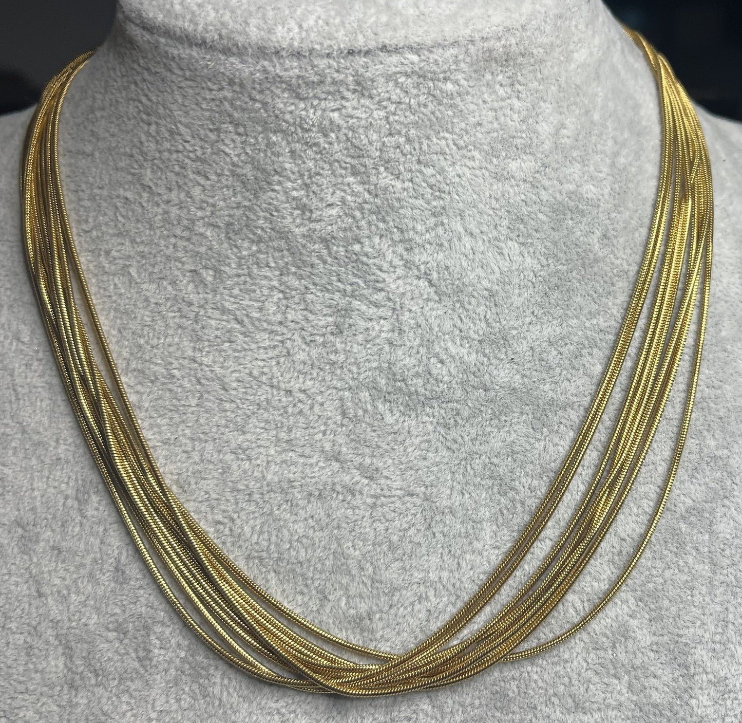 Collana multisnake dorata in acciaio su busto espositore