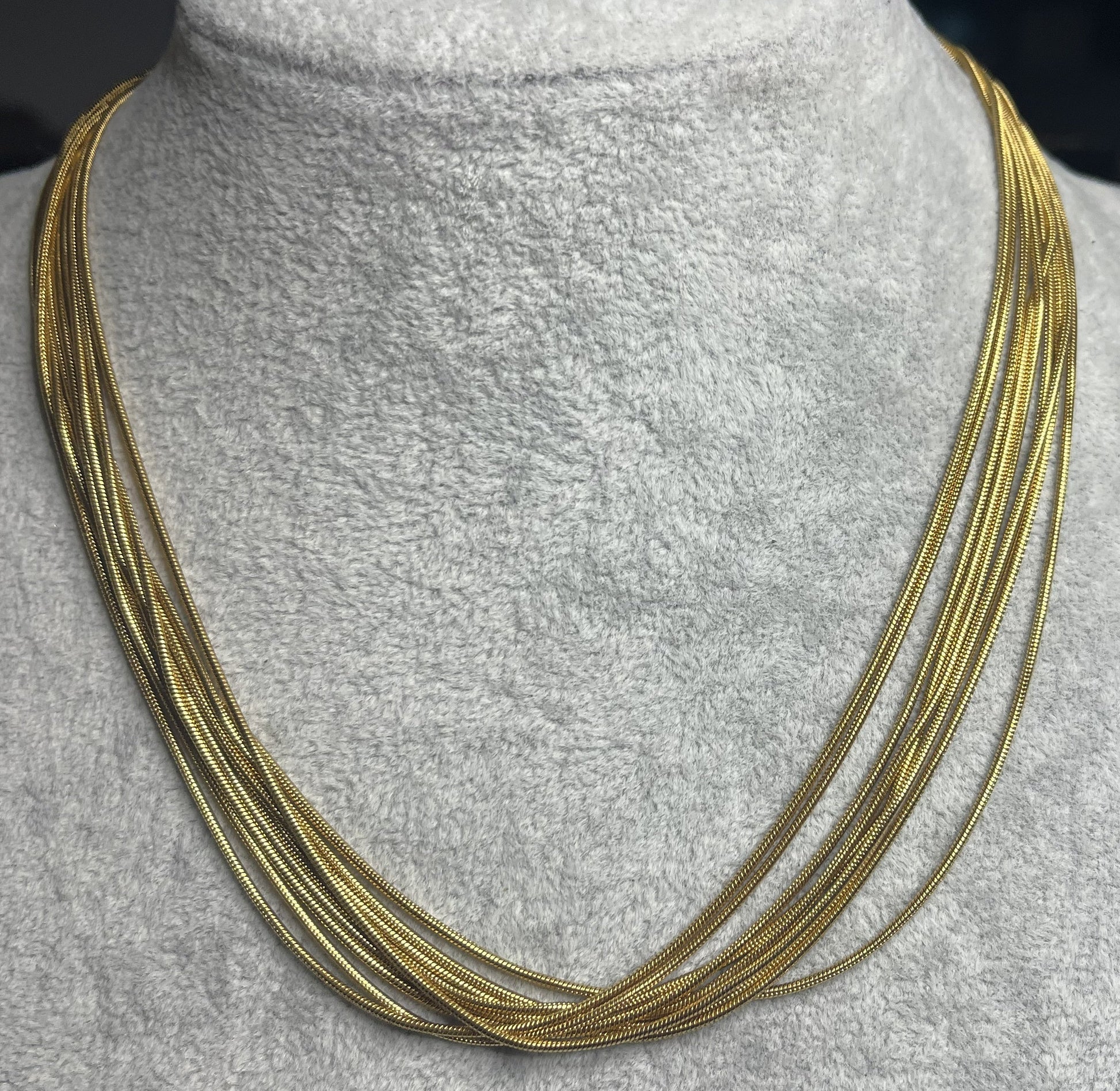 Collana multisnake dorata in acciaio su busto espositore