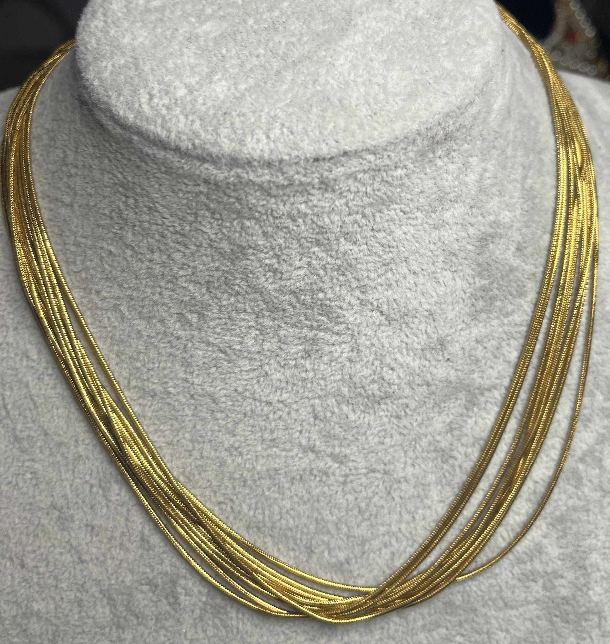 Collana multisnake dorata in acciaio su busto espositore