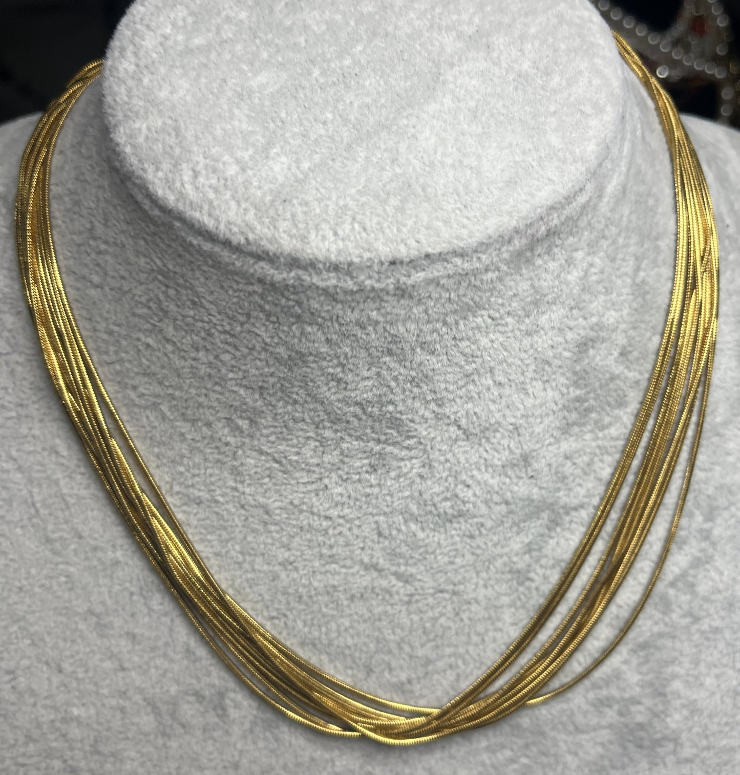 Collana multisnake dorata in acciaio su busto espositore