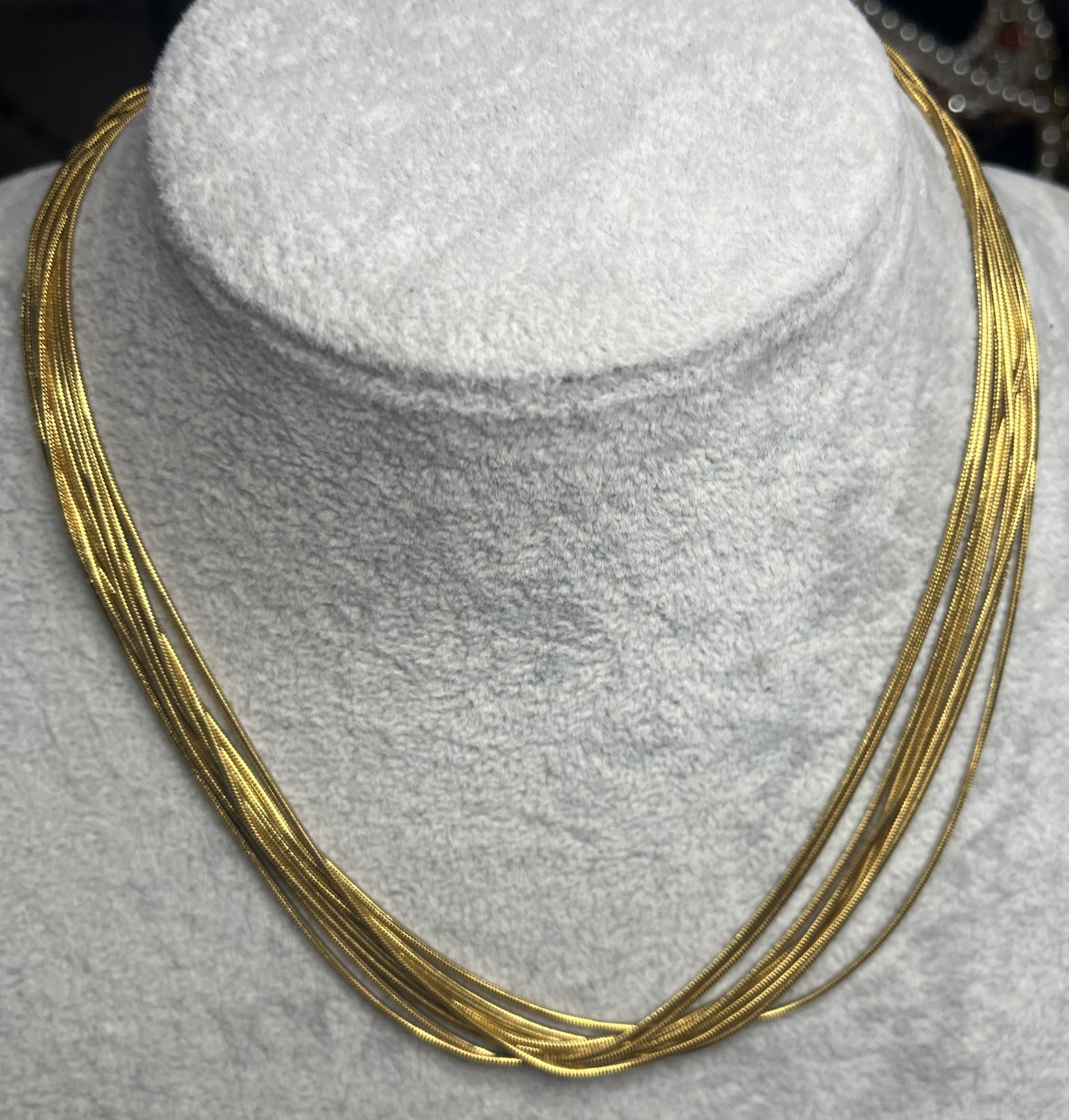 Collana multisnake dorata in acciaio su busto espositore