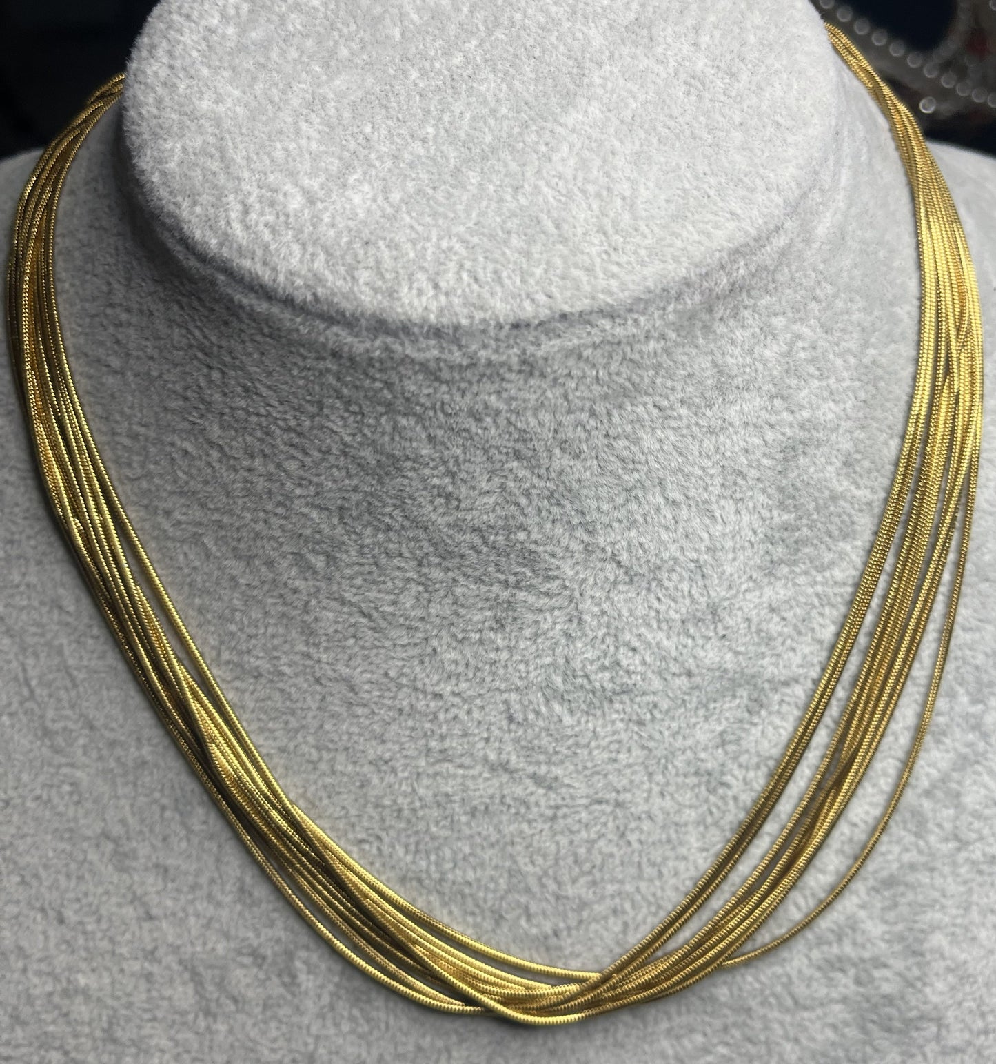 Collana multisnake dorata in acciaio su busto espositore
