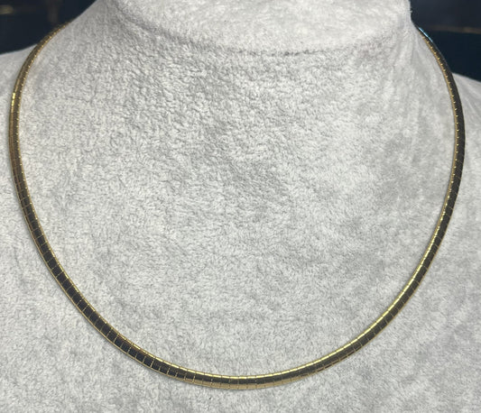 Collana Omega Serpentina Dorata elegante su busto espositore