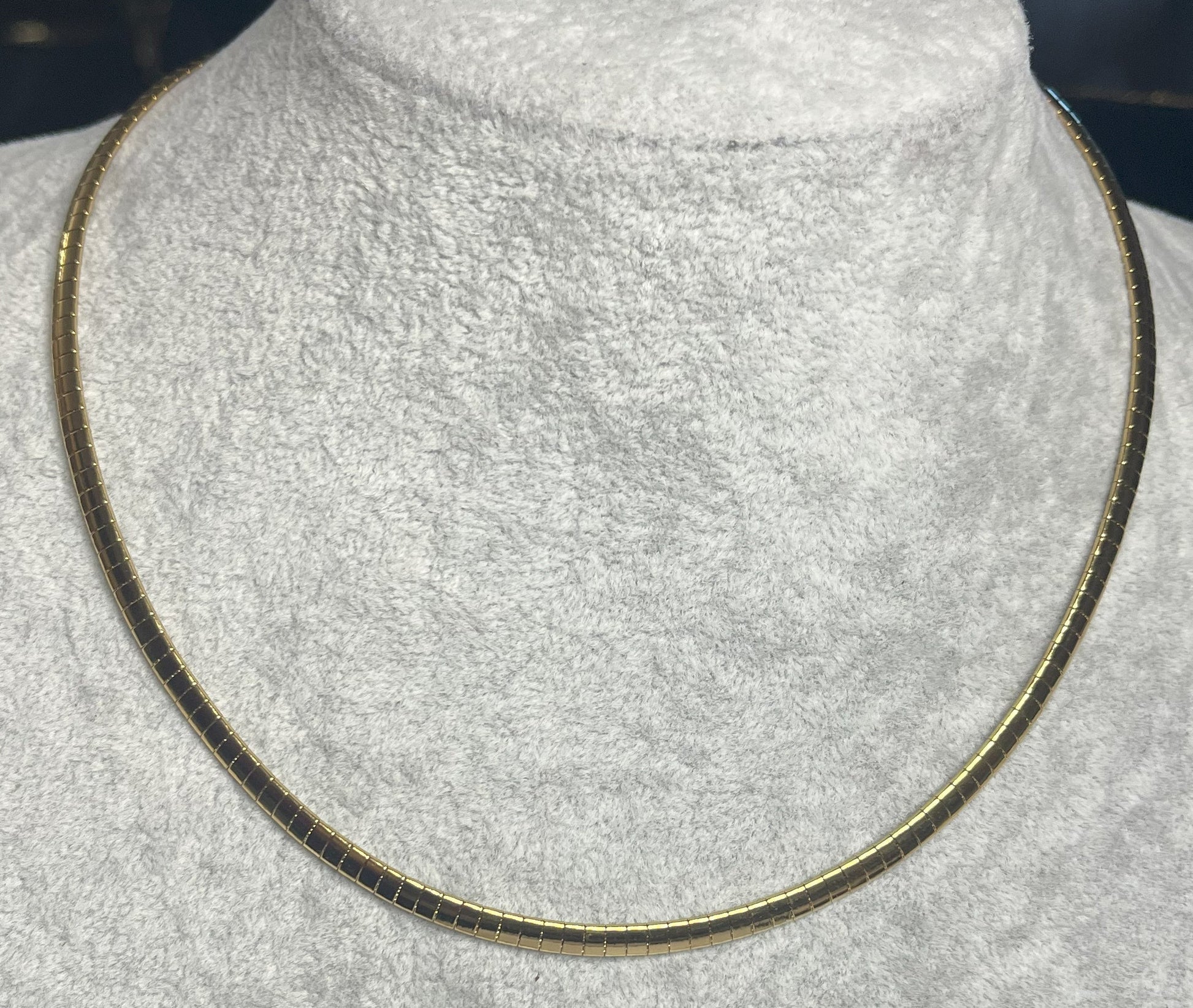 Collana Omega Serpentina Dorata elegante su busto espositore