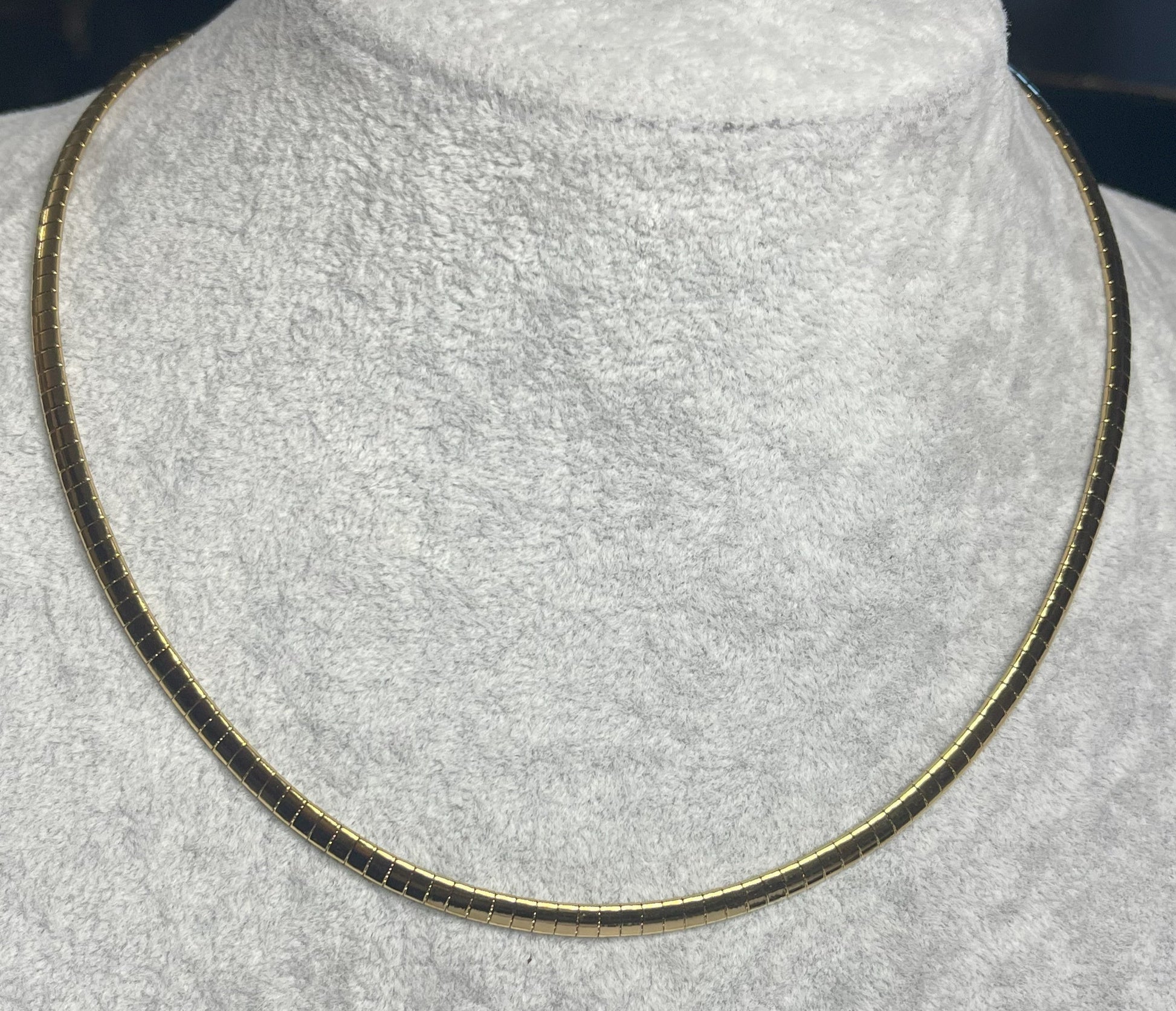 Collana Omega Serpentina Dorata elegante su busto espositore