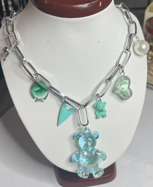 Collana chunky in alluminio trattato con orsetto turchese e pendenti verdi esposta su busto bianco