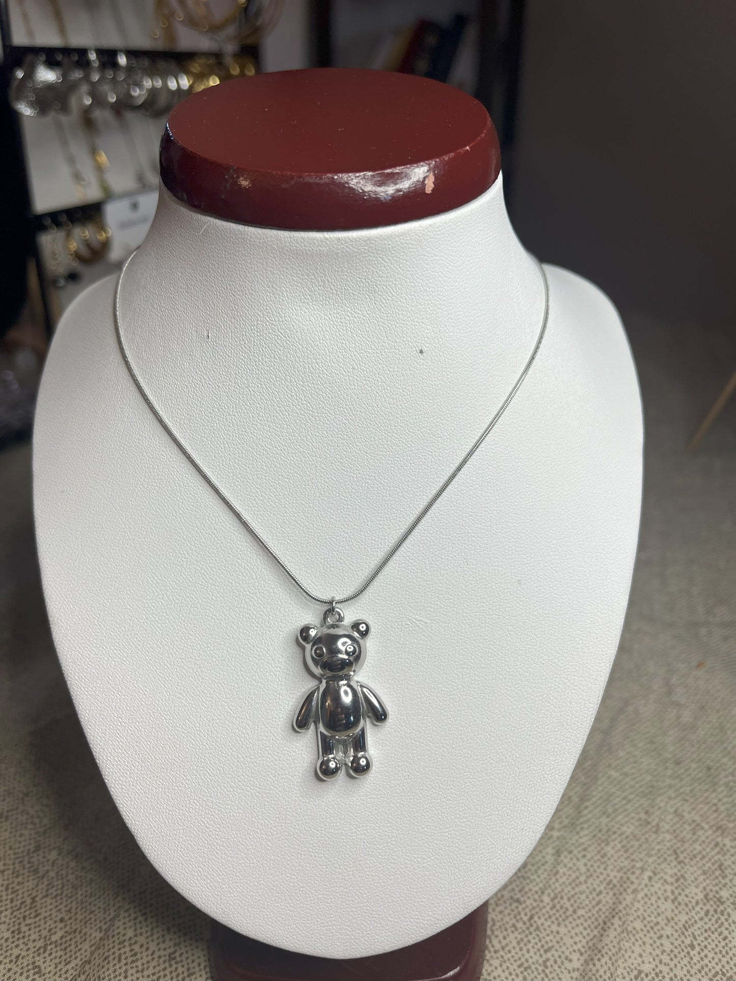 Collana Orsetto dei Sogni in acciaio premium con delicato ciondolo orsetto, variante placcato argento, esposta su busto espositore