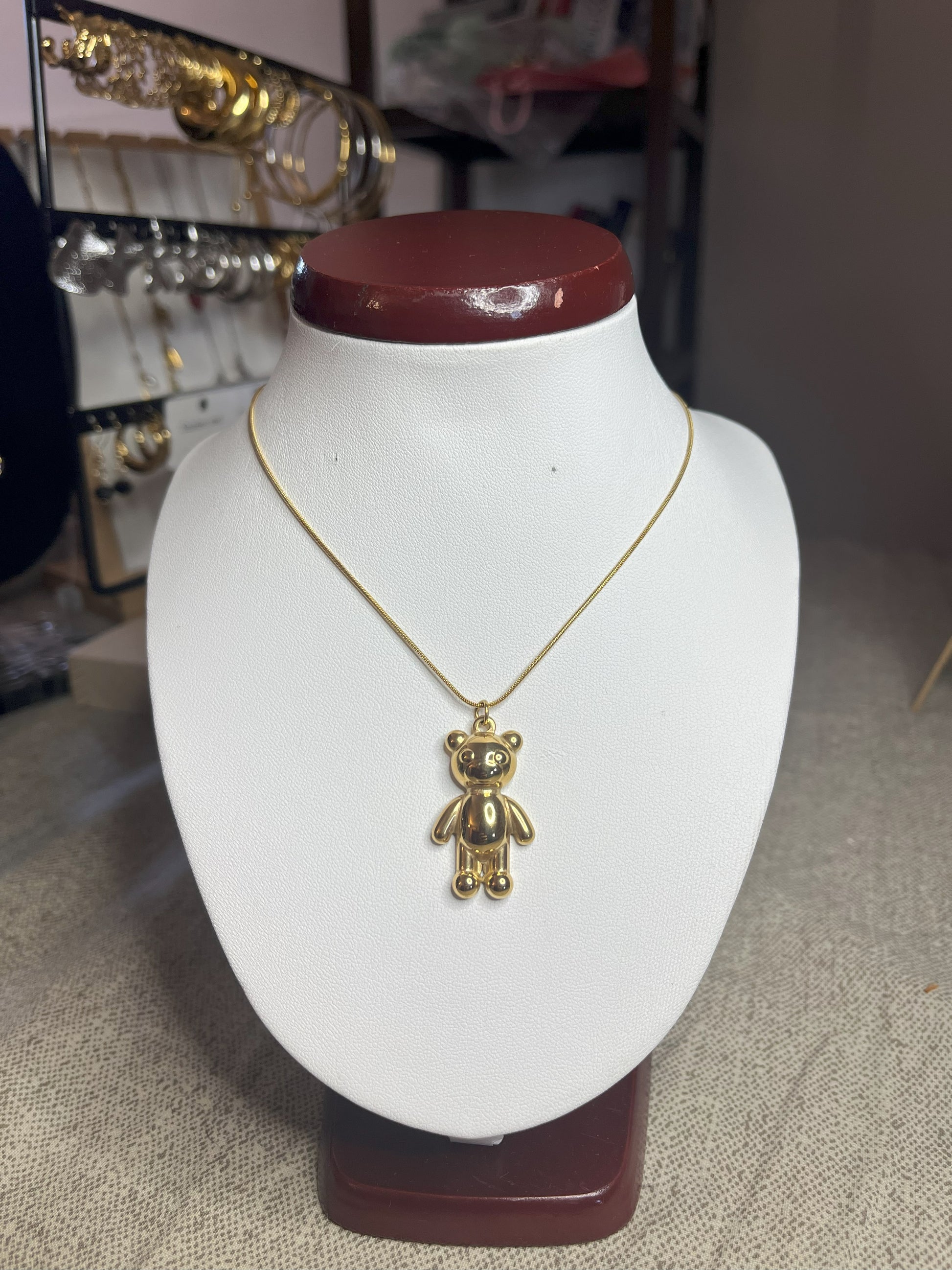 Collana Orsetto dei Sogni in acciaio premium con delicato ciondolo orsetto, variante placcato oro, esposta su busto espositore