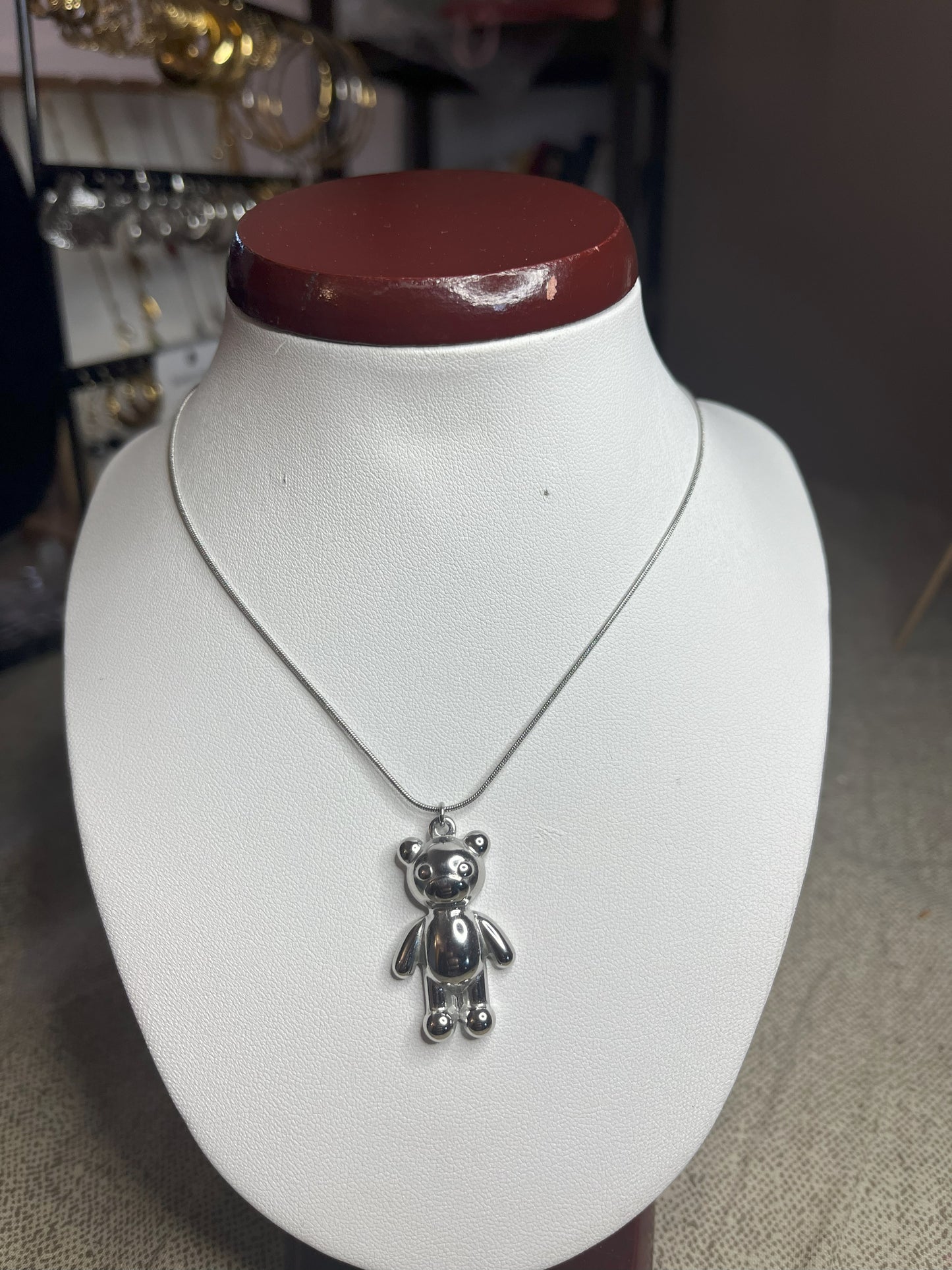 Collana Orsetto dei Sogni in acciaio premium con delicato ciondolo orsetto, variante placcato argento, esposta su busto espositore