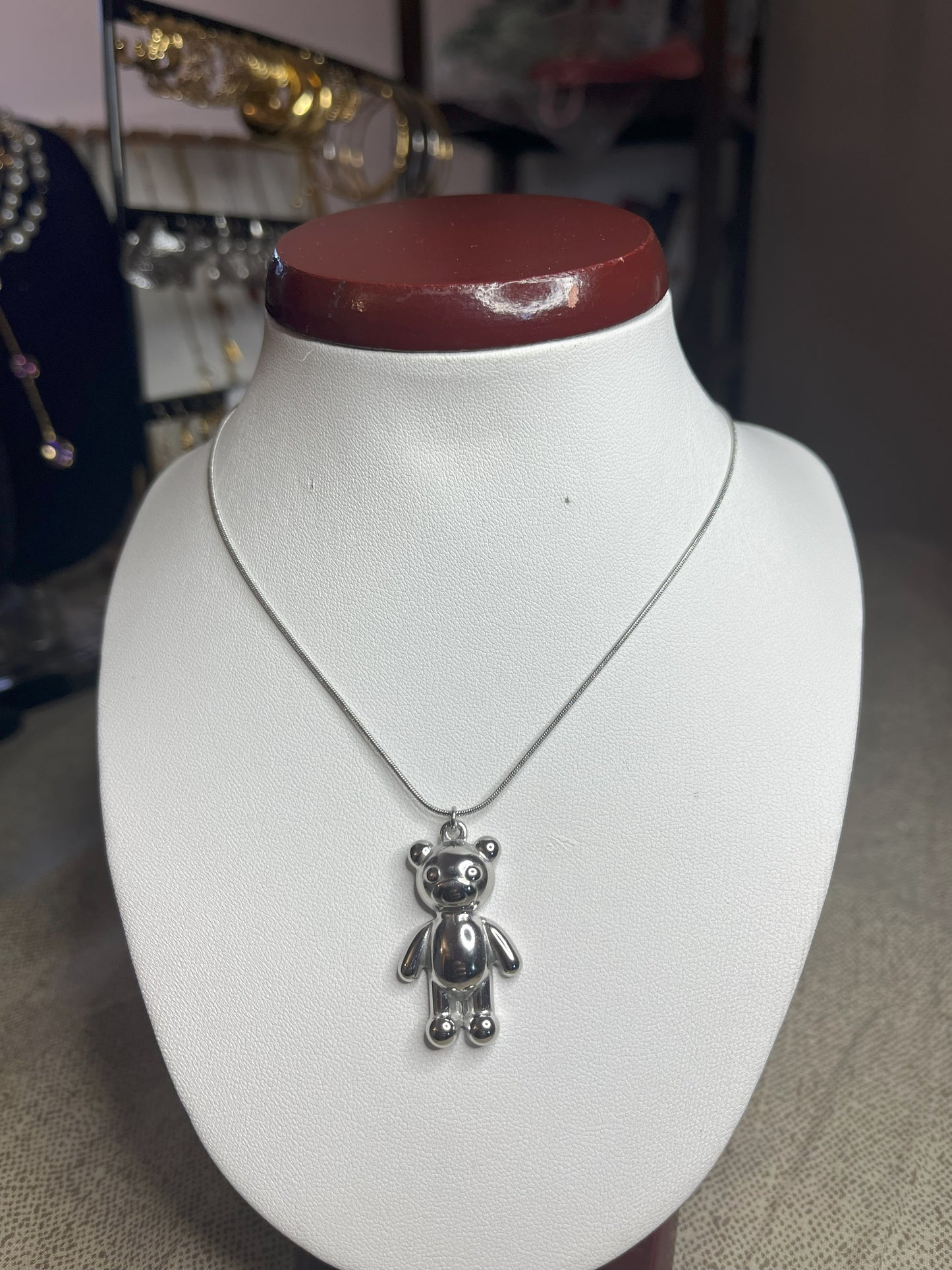 Collana Orsetto dei Sogni in acciaio premium con delicato ciondolo orsetto, variante placcato argento, esposta su busto espositore