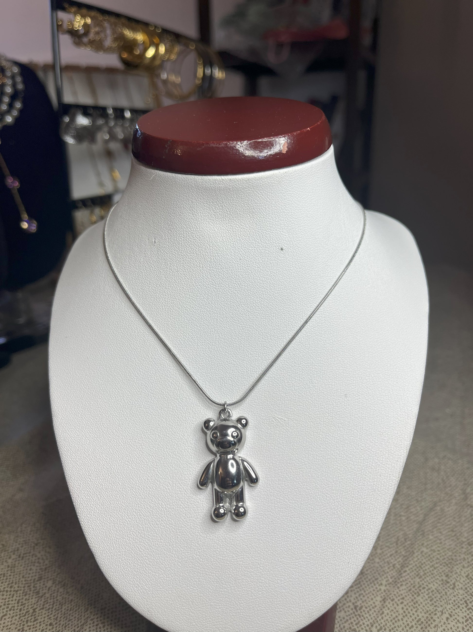 Collana Orsetto dei Sogni in acciaio premium con delicato ciondolo orsetto, variante placcato argento, esposta su busto espositore