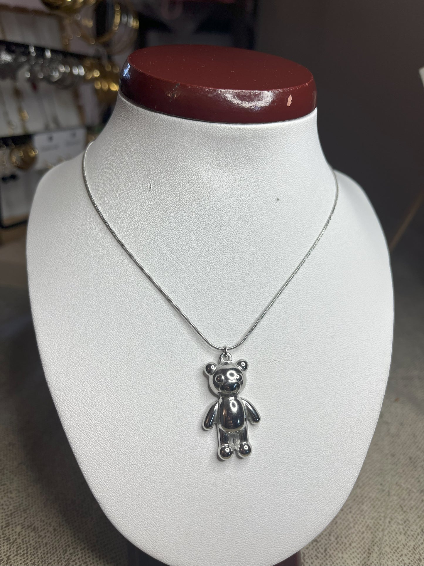 Collana Orsetto dei Sogni in acciaio premium con delicato ciondolo orsetto, variante placcato argento, esposta su busto espositore