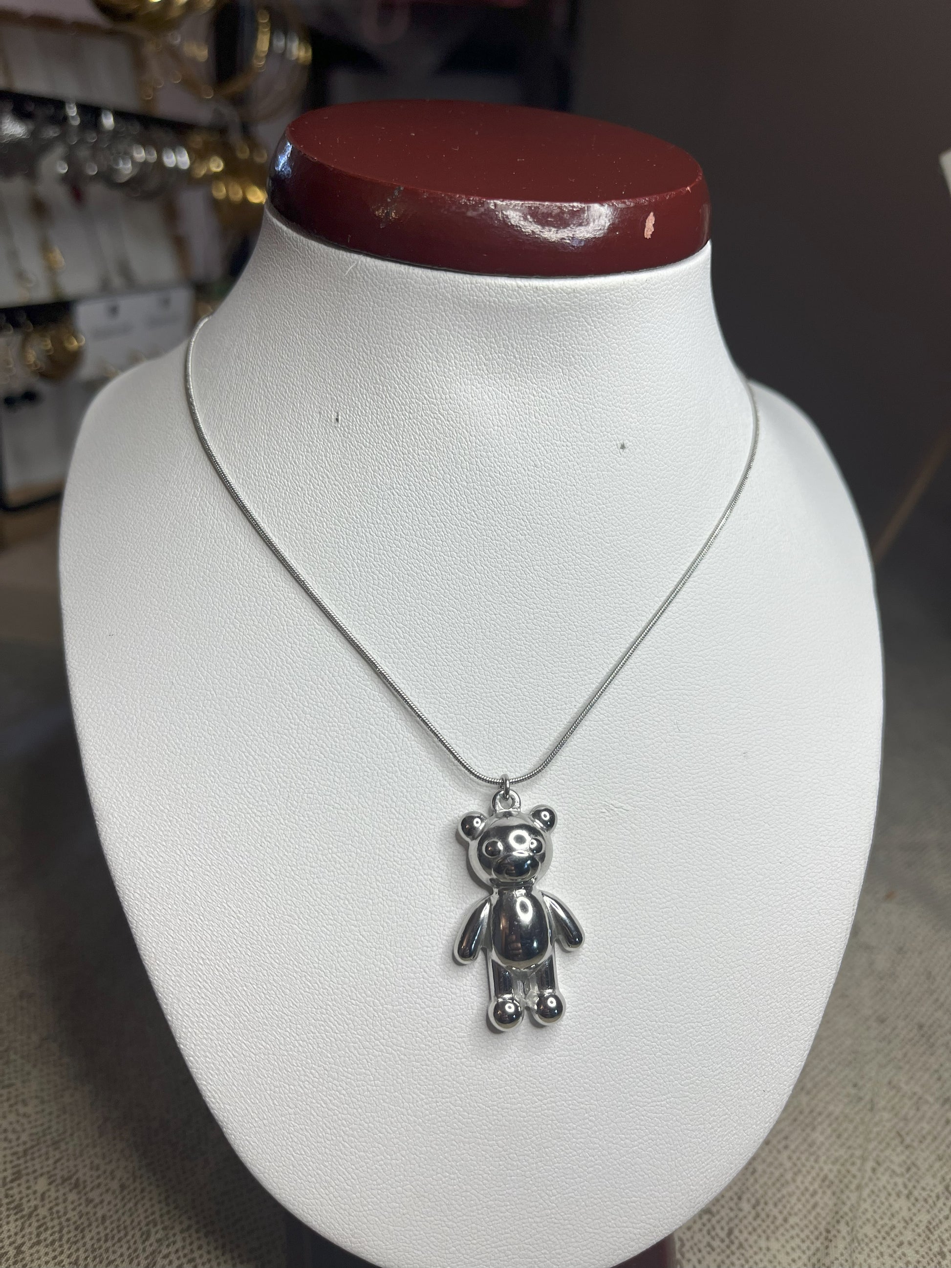 Collana Orsetto dei Sogni in acciaio premium con delicato ciondolo orsetto, variante placcato argento, esposta su busto espositore