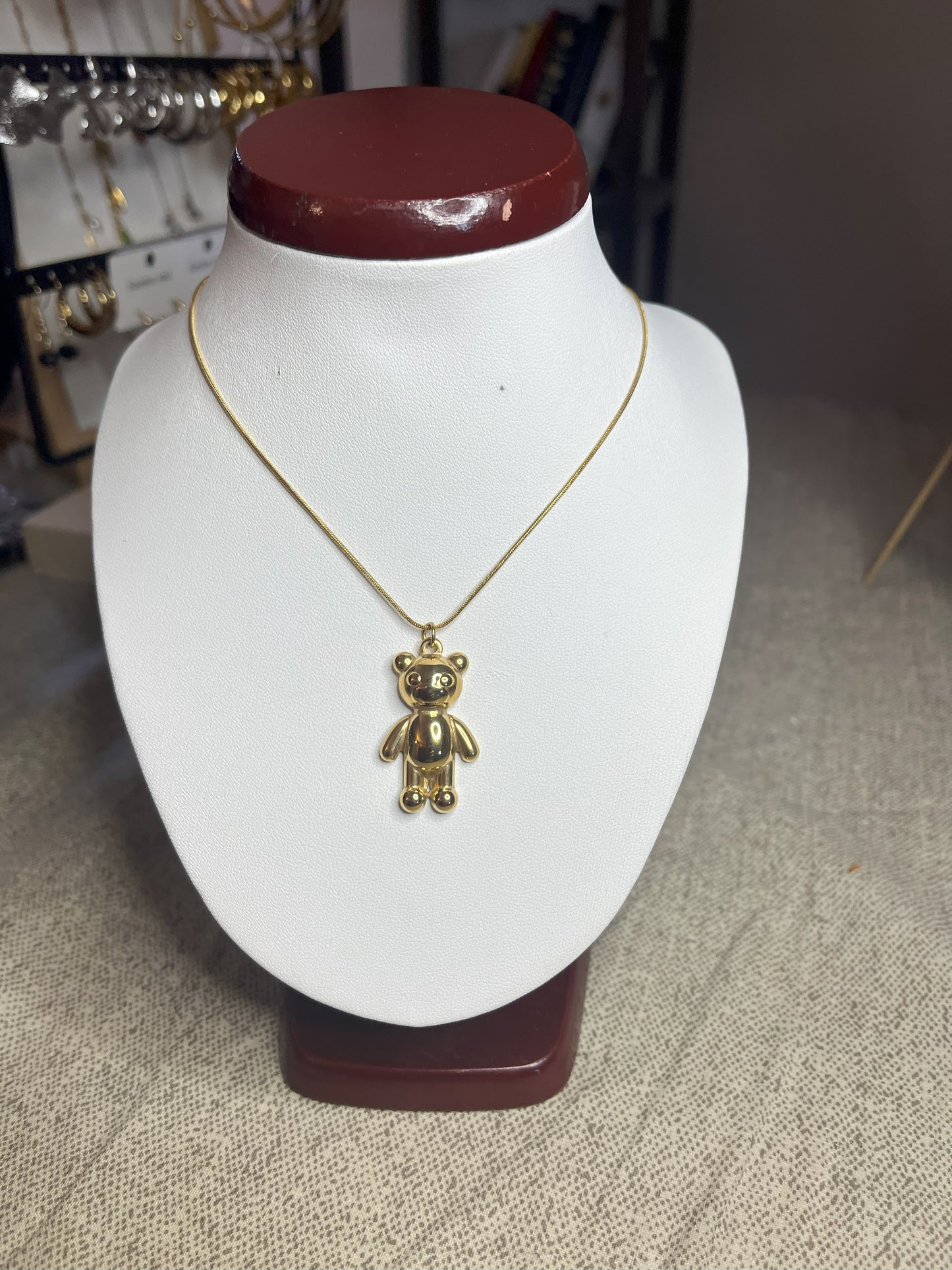 Collana Orsetto dei Sogni in acciaio premium con delicato ciondolo orsetto, variante placcato oro, esposta su busto espositore