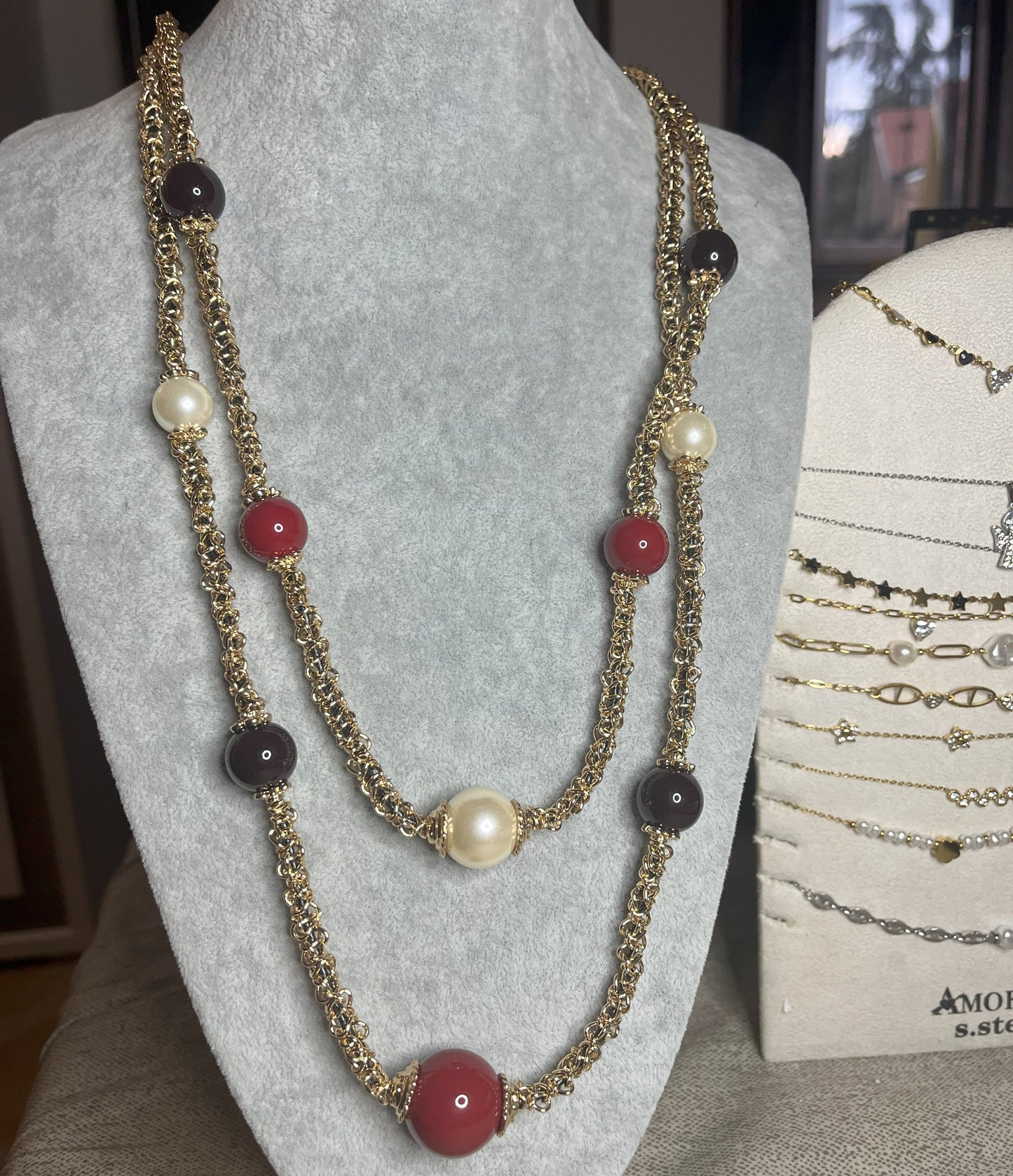 Collana Perle Preziose Multi - design multi-strand con perle nere, bianche e rosse su busto
