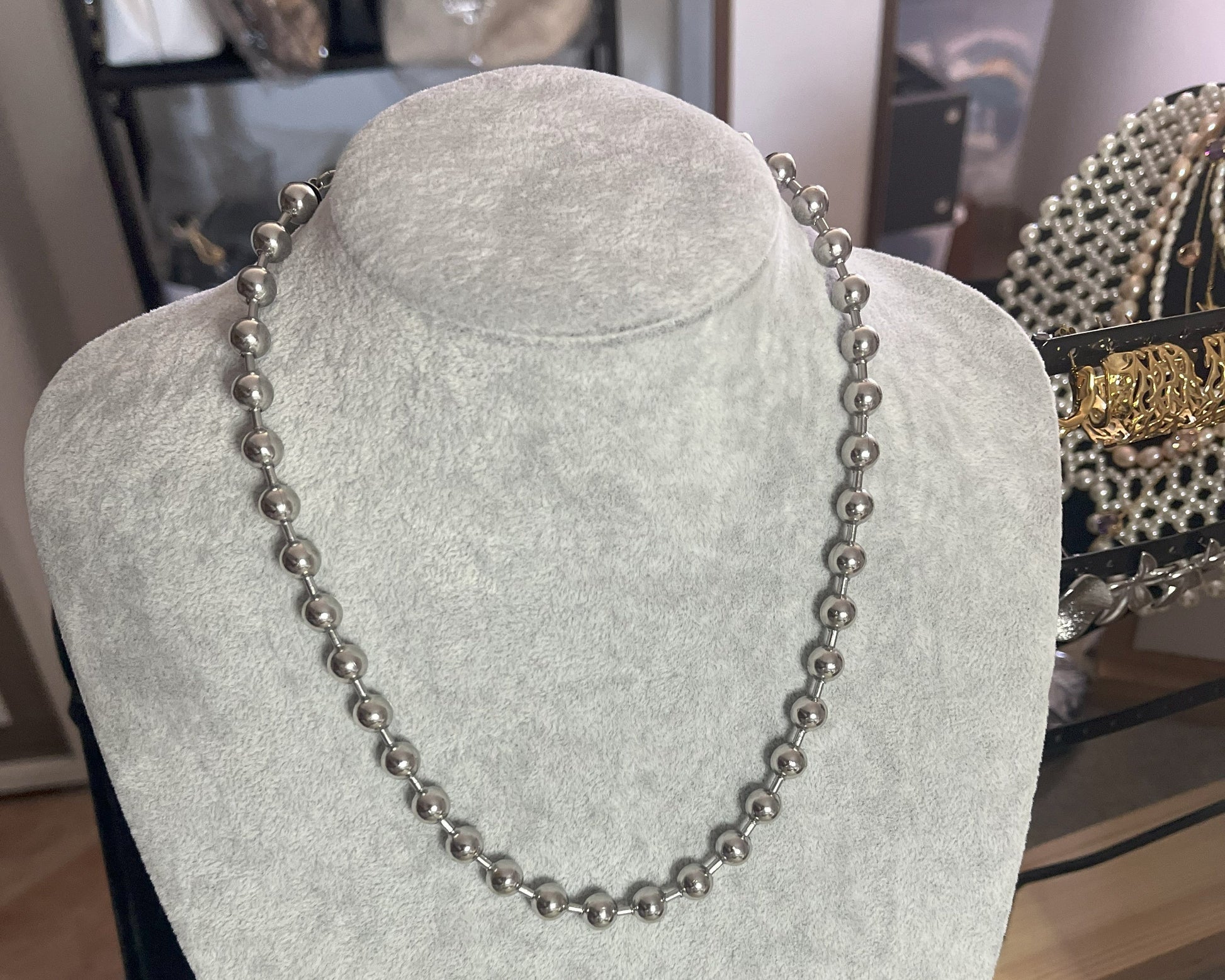Collana Sfere in acciaio inox placcato argento con sfere metalliche uniformi, esposta su busto grigio chiaro