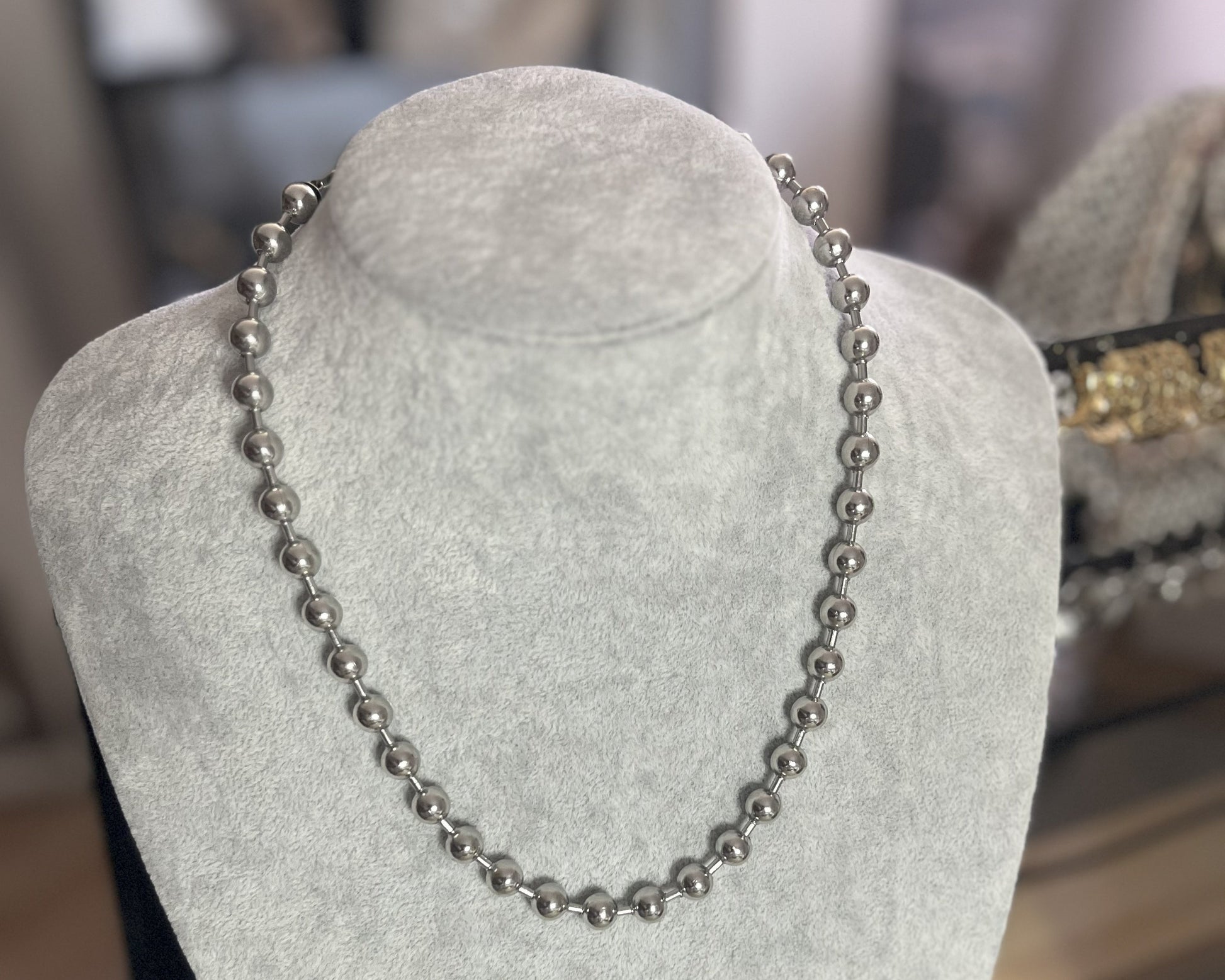 Collana Sfere in acciaio inox placcato argento con sfere metalliche uniformi, esposta su busto grigio chiaro