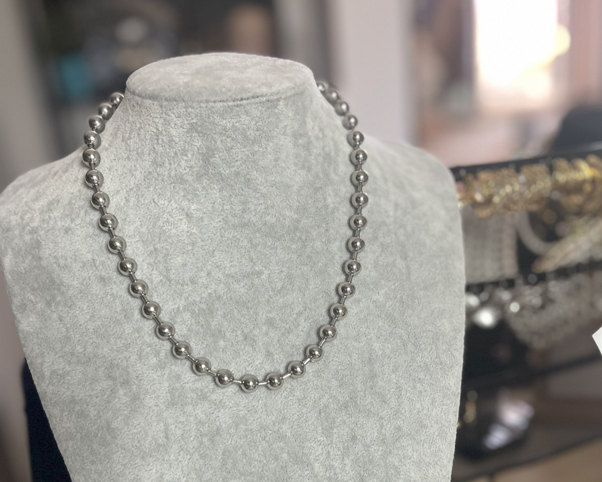 Collana Sfere in acciaio inox placcato argento con sfere metalliche uniformi, esposta su busto grigio chiaro