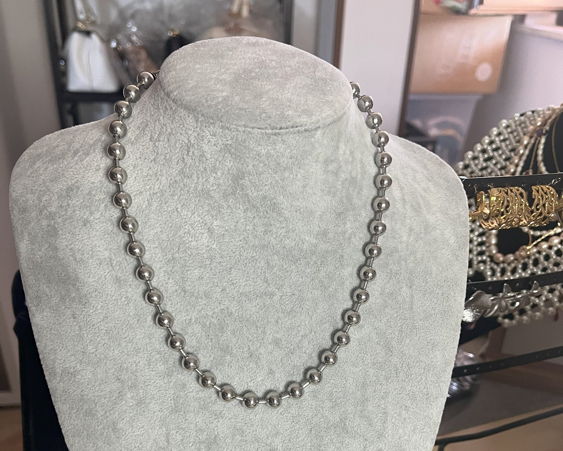 Collana Sfere in acciaio inox placcato argento con sfere metalliche uniformi, esposta su busto grigio chiaro