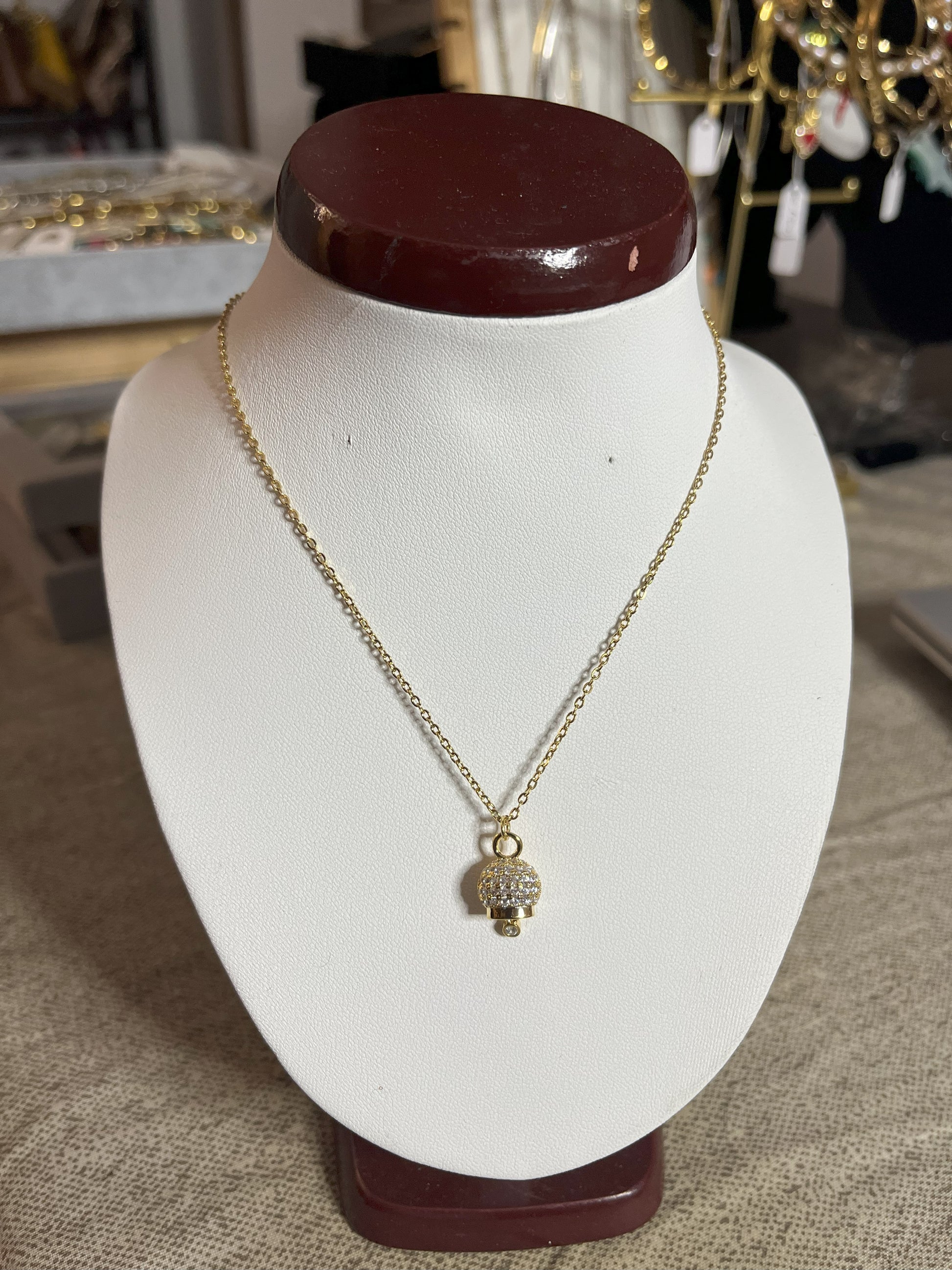 Collana Sweet Charm con catena dorata fine e ciondolo decorativo brillante su espositore bianco, design dolce e romantico per donna