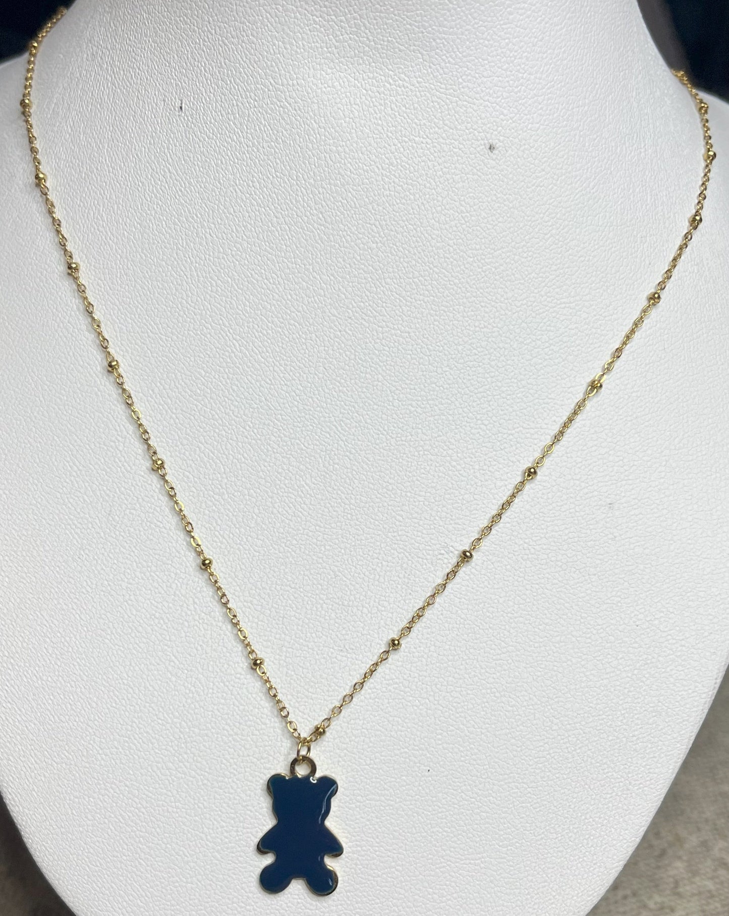 Collana Teddy con ciondolo orsetto blu in smalto e catena dorata, esposta su busto bianco
