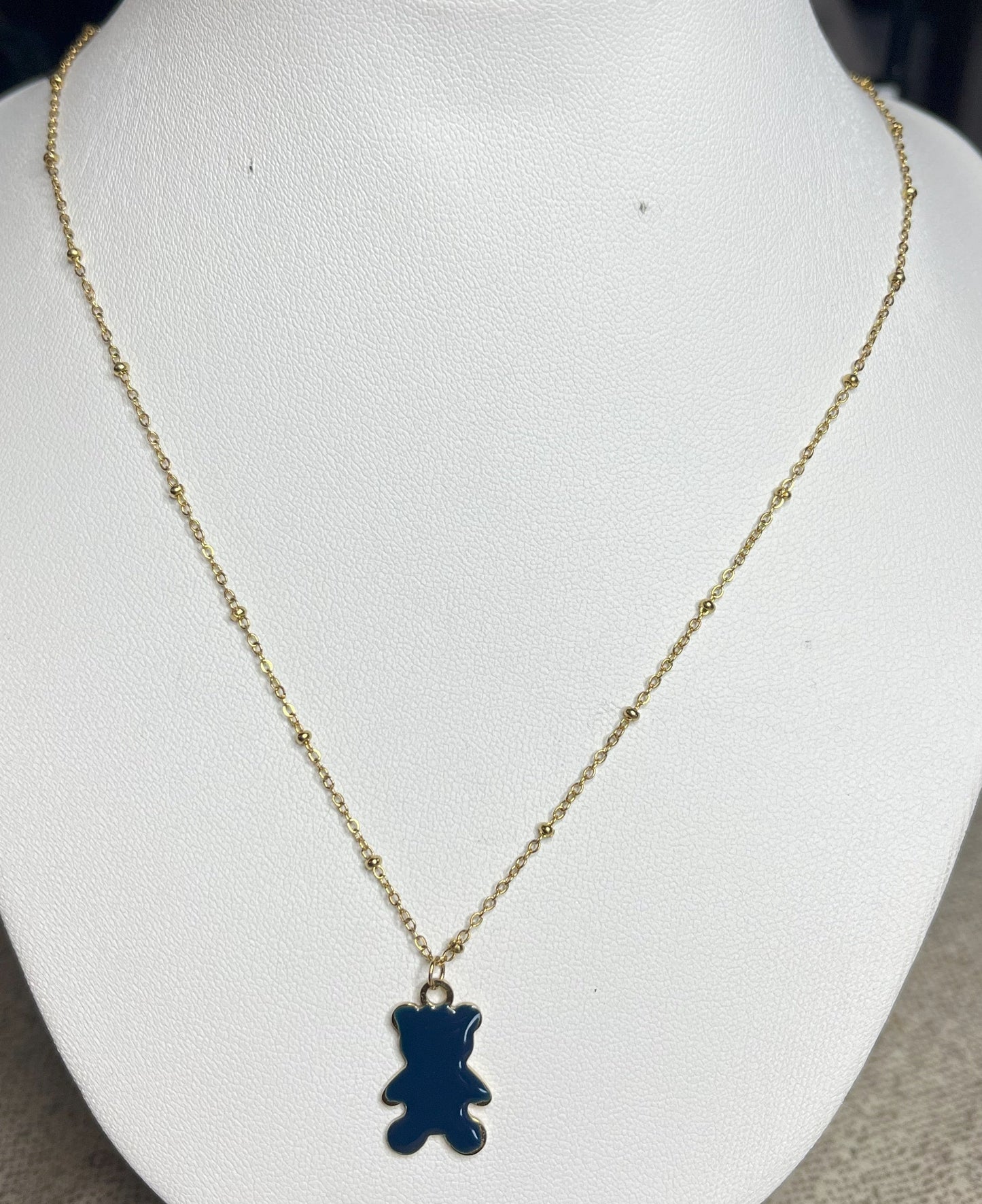 Collana Teddy con ciondolo orsetto blu in smalto e catena dorata, esposta su busto bianco