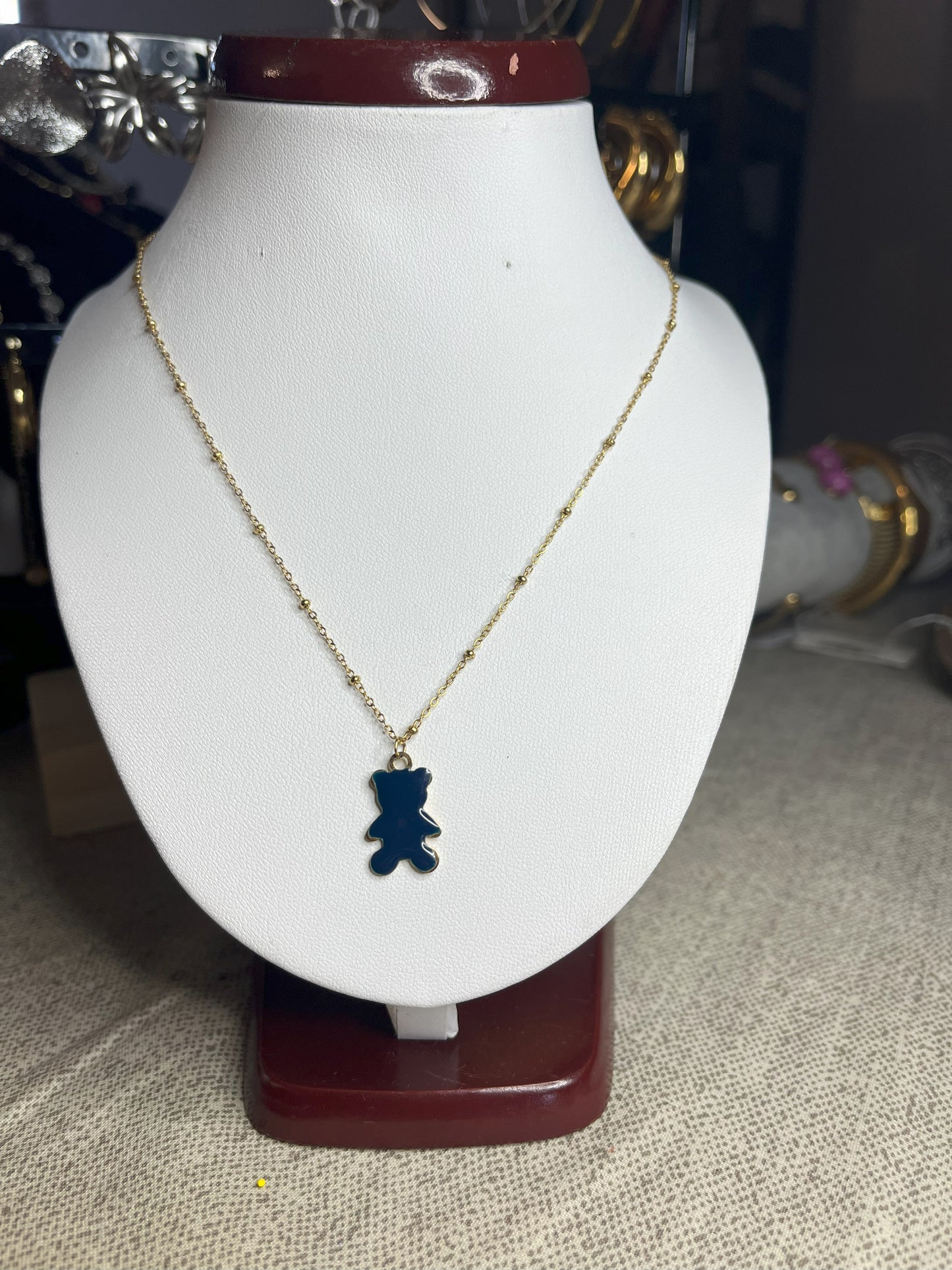 Collana Teddy con ciondolo orsetto blu in smalto e catena dorata, esposta su busto bianco