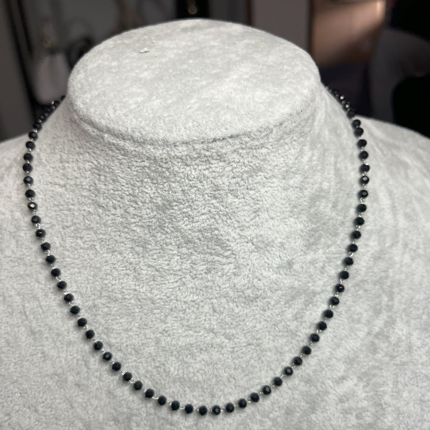 collana di perline nera su busto chiaro