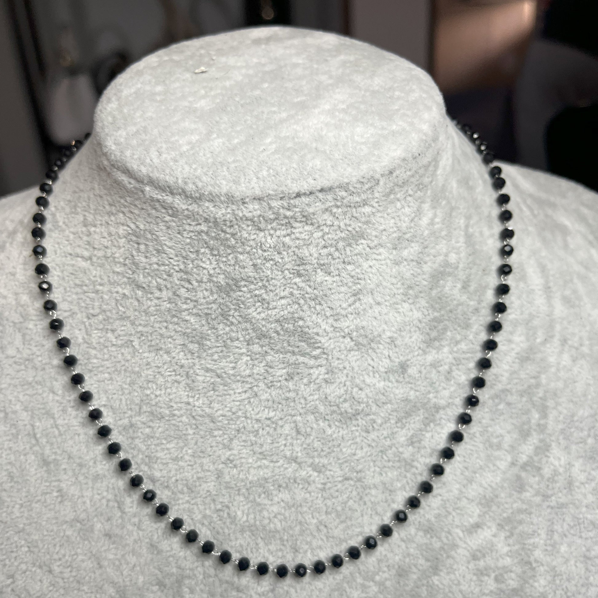 collana di perline nera su busto chiaro