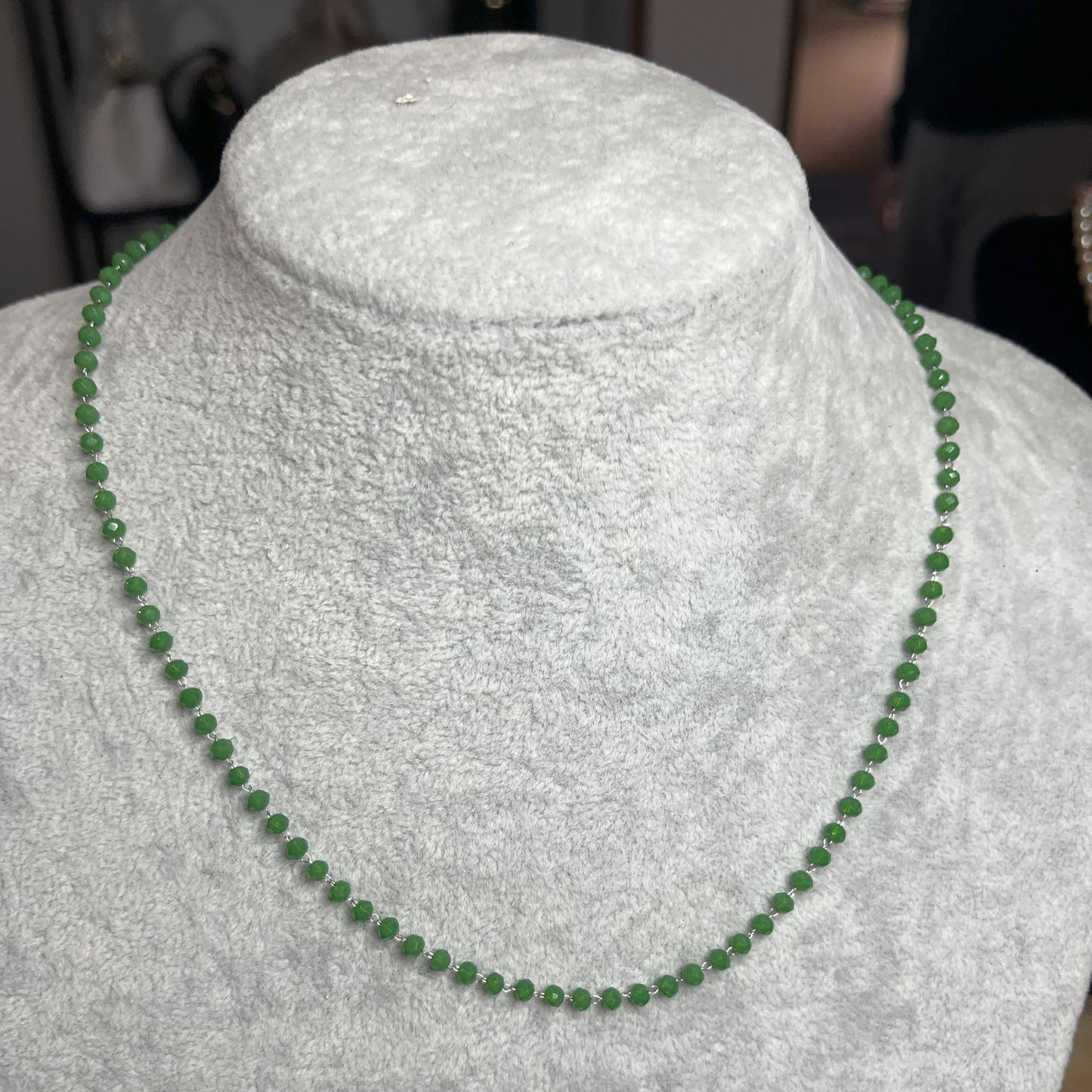 collana di perline verde su busto chiaro