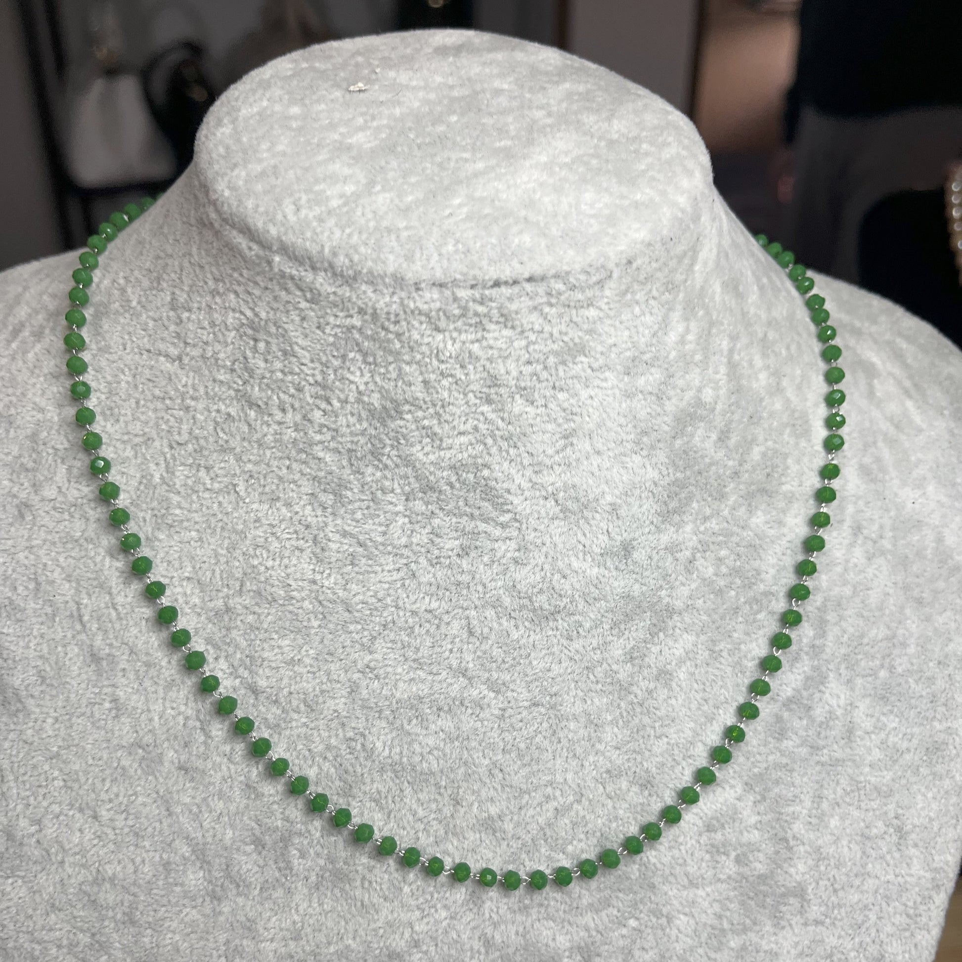 collana di perline verde su busto chiaro