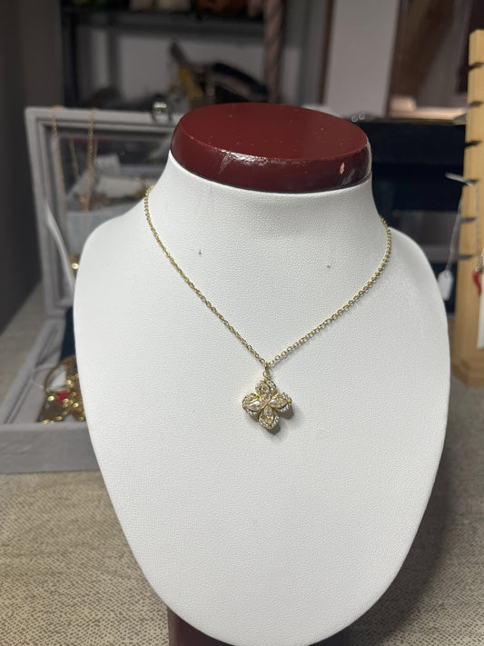 Collana in acciaio con ciondolo quadrifoglio decorato con zirconi su busto espositore bianco con base rossa