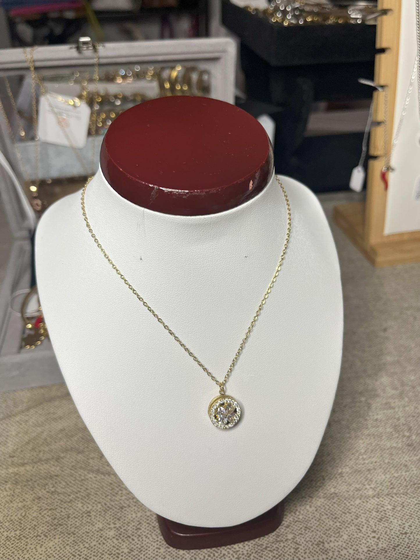 Collana Wish con elegante ciondolo quadrifoglio dorato e dettagli scintillanti, esposta su busto porta gioielli bianco