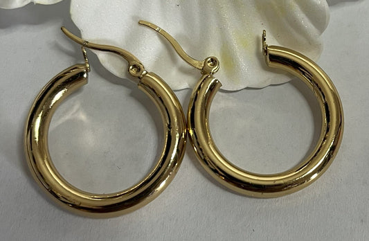 Orecchini creoli dorati placcati oro a forma di cerchio con finitura lucida su sfondo bianco