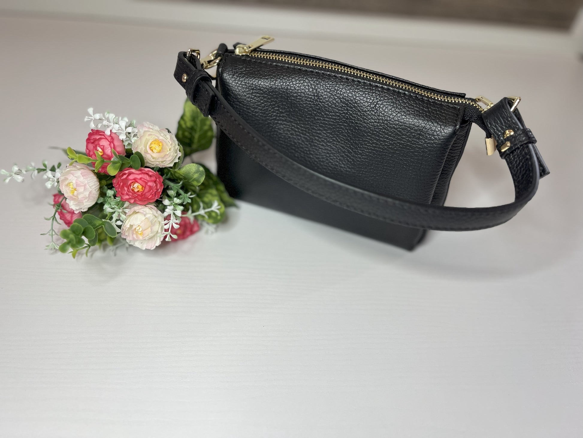 Elegante borsa crossbody nera in pelle martellata con finiture dorate e tracolla regolabile