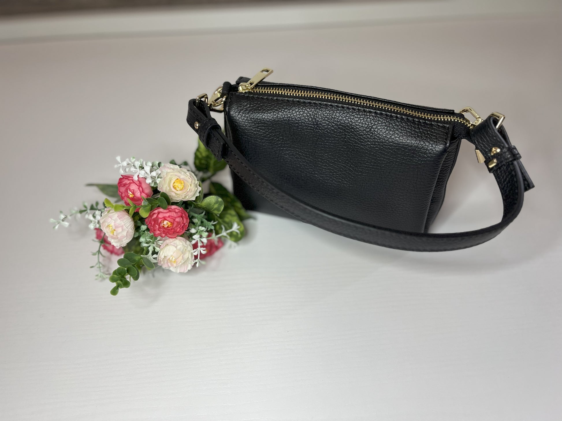 Elegante borsa crossbody nera in pelle martellata con finiture dorate e tracolla regolabile