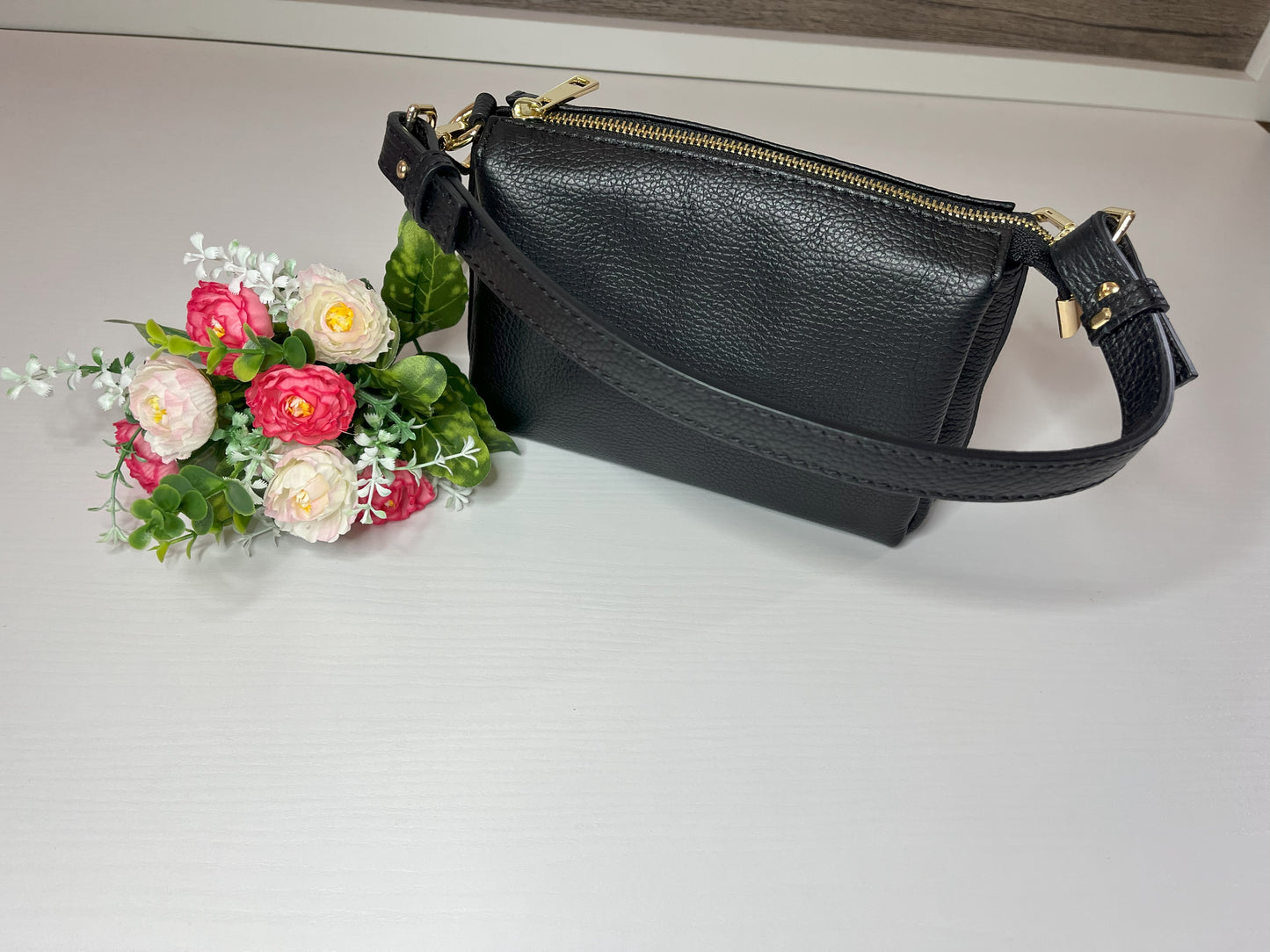 Elegante borsa crossbody nera in pelle martellata con finiture dorate e tracolla regolabile