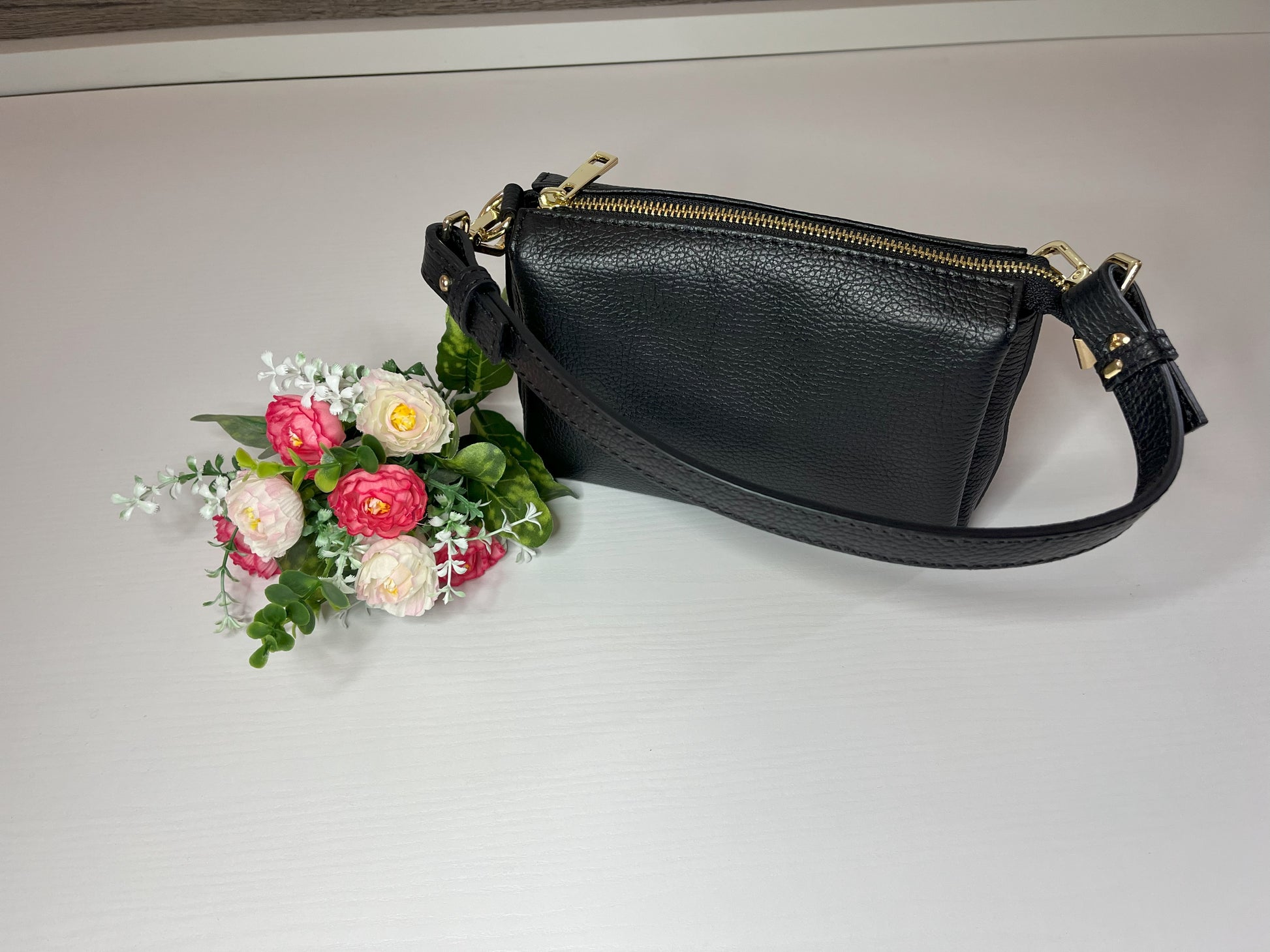 Elegante borsa crossbody nera in pelle martellata con finiture dorate e tracolla regolabile