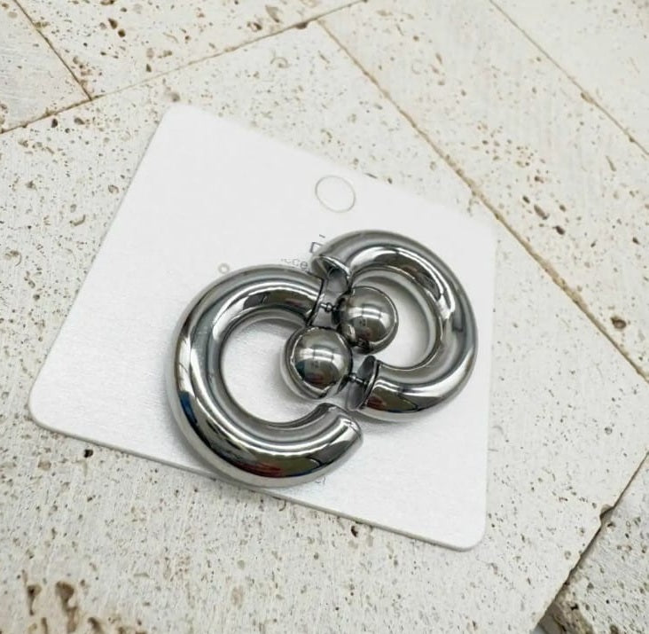 recchini Earcuff premium placcati oro con design curvo a C avvolgente, fotografati su superficie marmorizzata bianca