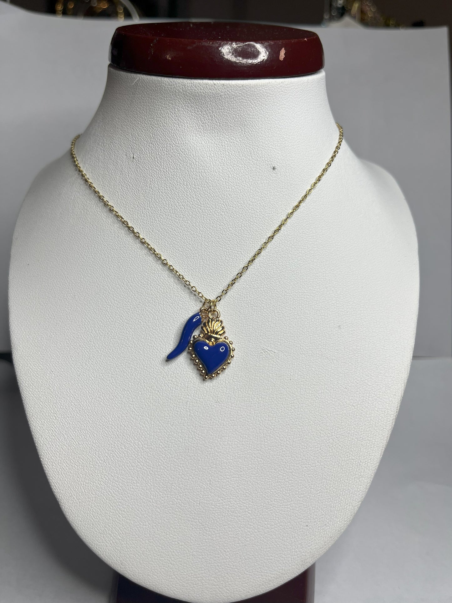 Collana Love Charm con catena dorata e doppio pendente a forma di cuore e cornetto portafortuna, disponibile in vari colori