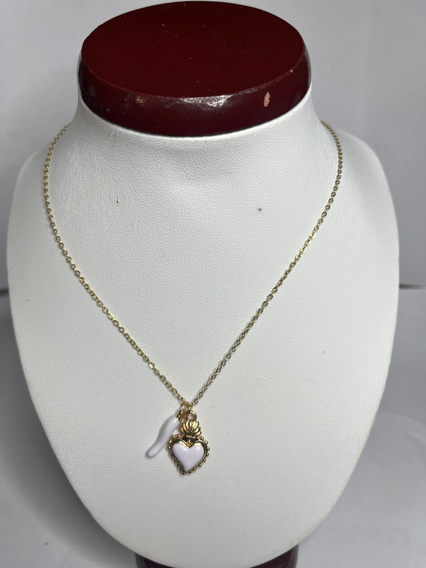 Collana Love Charm con catena dorata e doppio pendente a forma di cuore e cornetto portafortuna, disponibile in vari colori