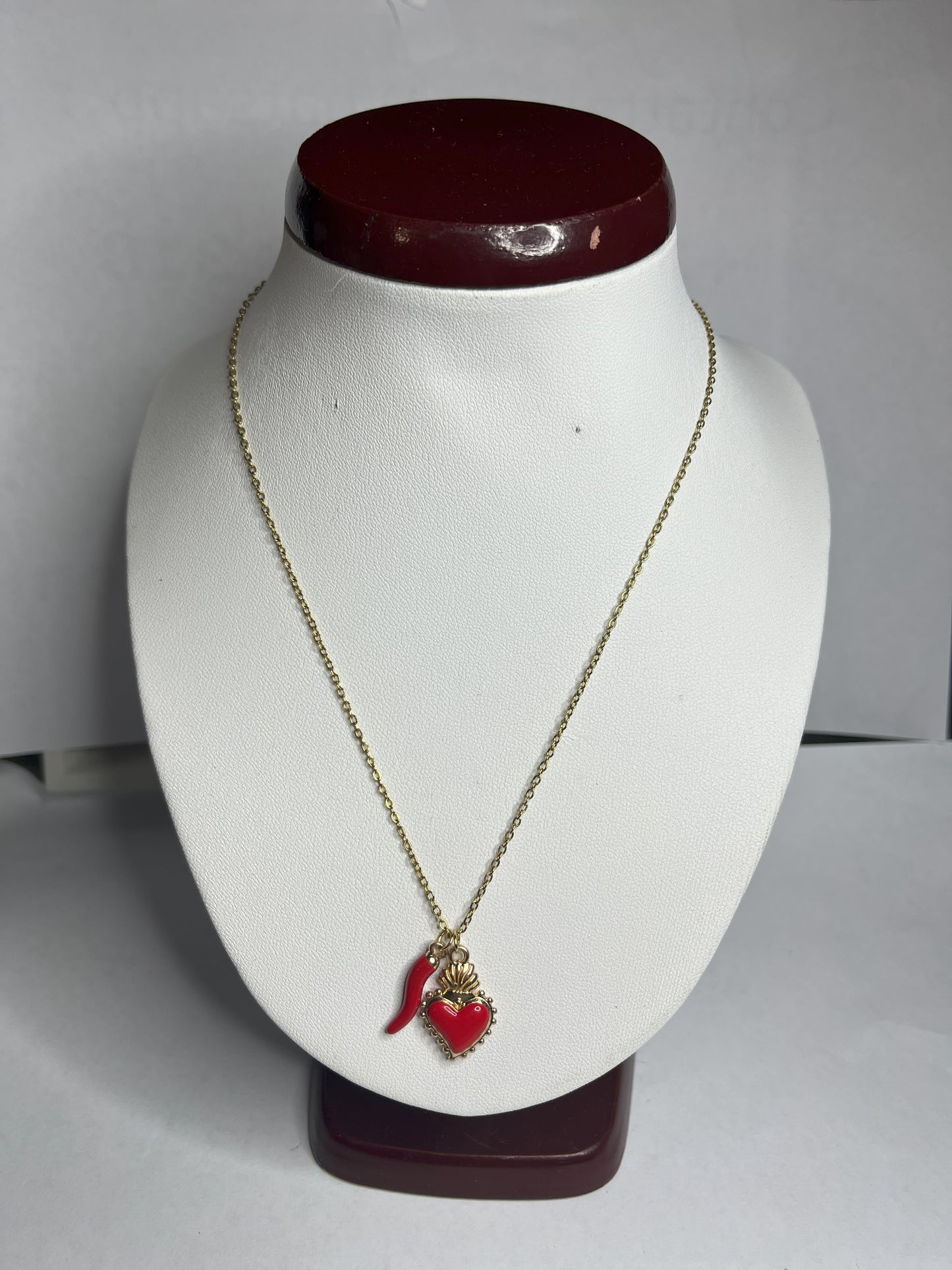 Collana Love Charm con catena dorata e doppio pendente a forma di cuore e cornetto portafortuna, disponibile in vari colori