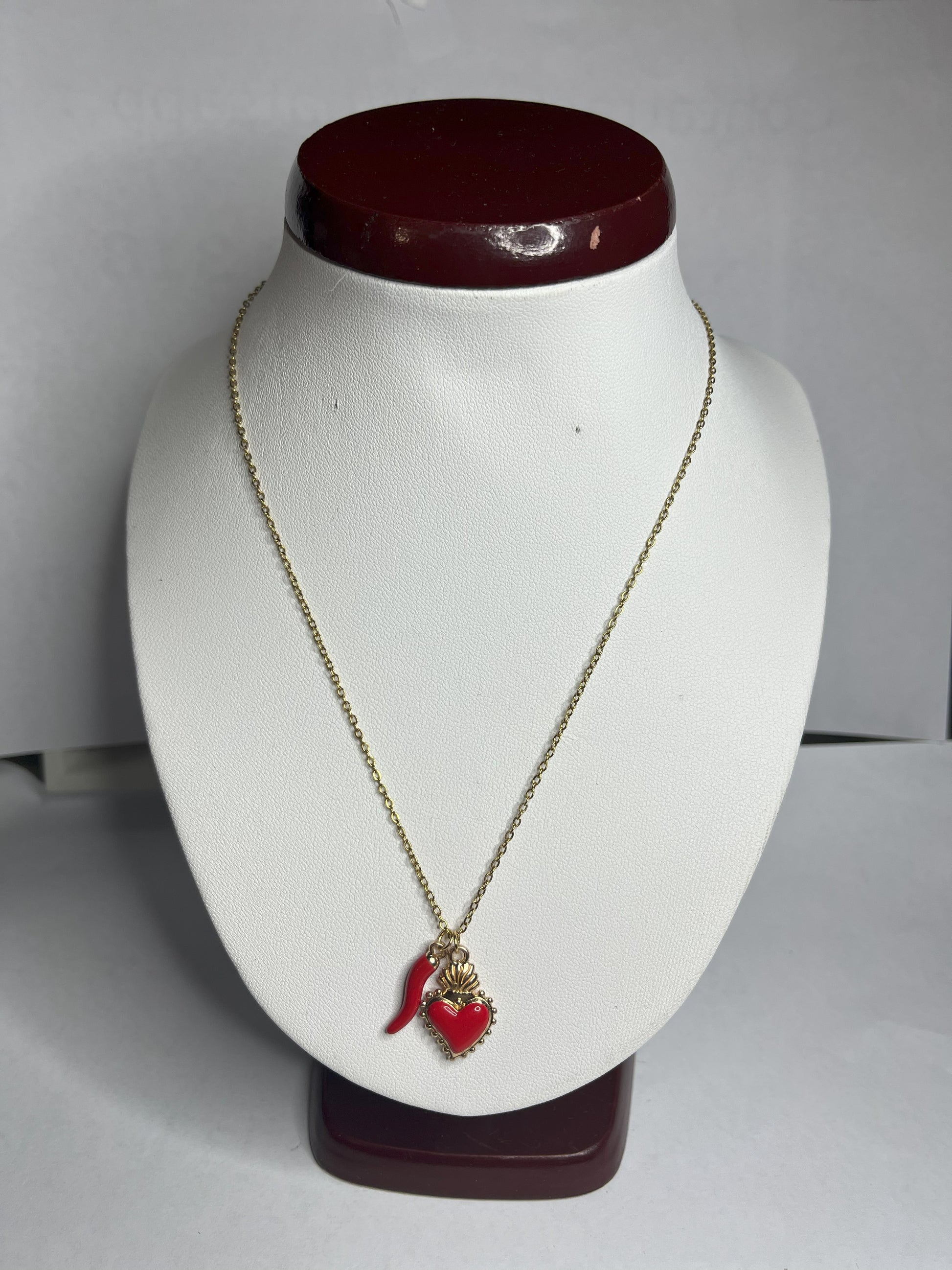 Collana Love Charm con catena dorata e doppio pendente a forma di cuore e cornetto portafortuna, disponibile in vari colori