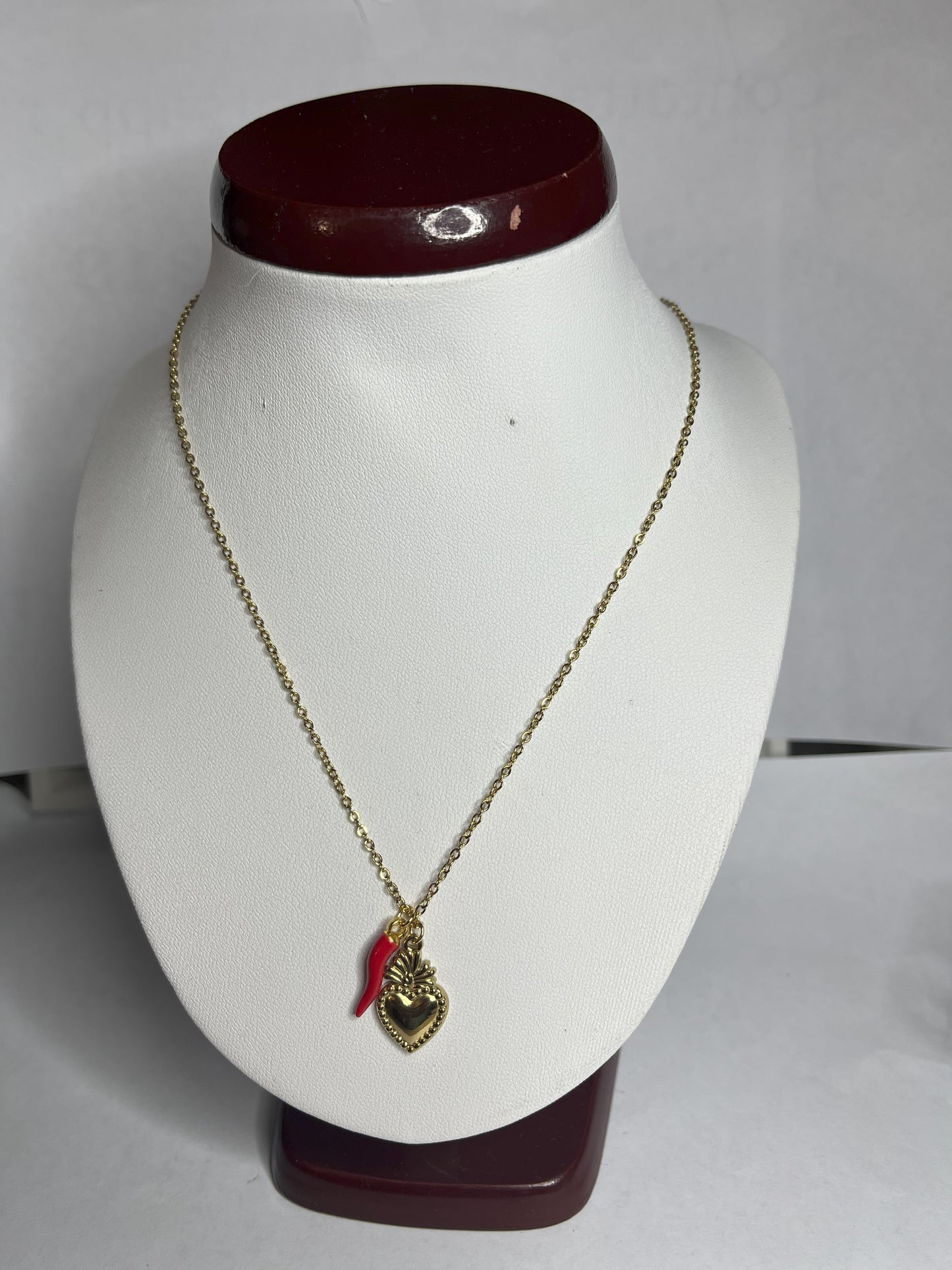 Collana Love Charm con catena dorata e doppio pendente a forma di cuore e cornetto portafortuna, disponibile in vari colori