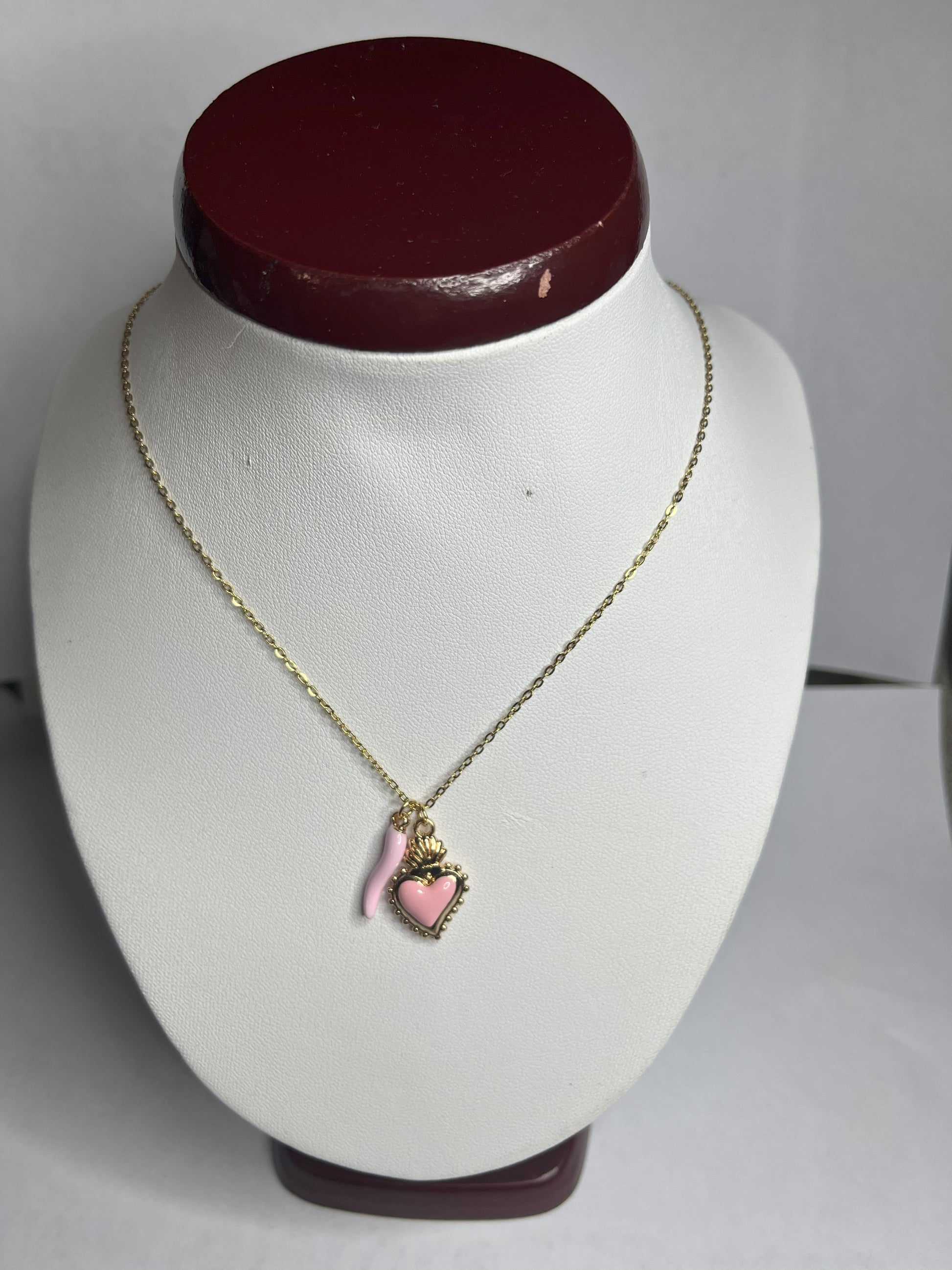 Collana Love Charm con catena dorata e doppio pendente a forma di cuore e cornetto portafortuna, disponibile in vari colori