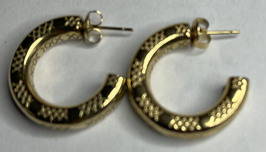 Orecchini a cerchio placcati oro con texture decorativa tridimensionale, appoggiati su corallo bianco