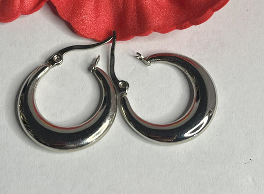 Set di orecchini creoli placcati, due paia in oro e argento, disposti su sfondo neutro con fiore rosso decorativo